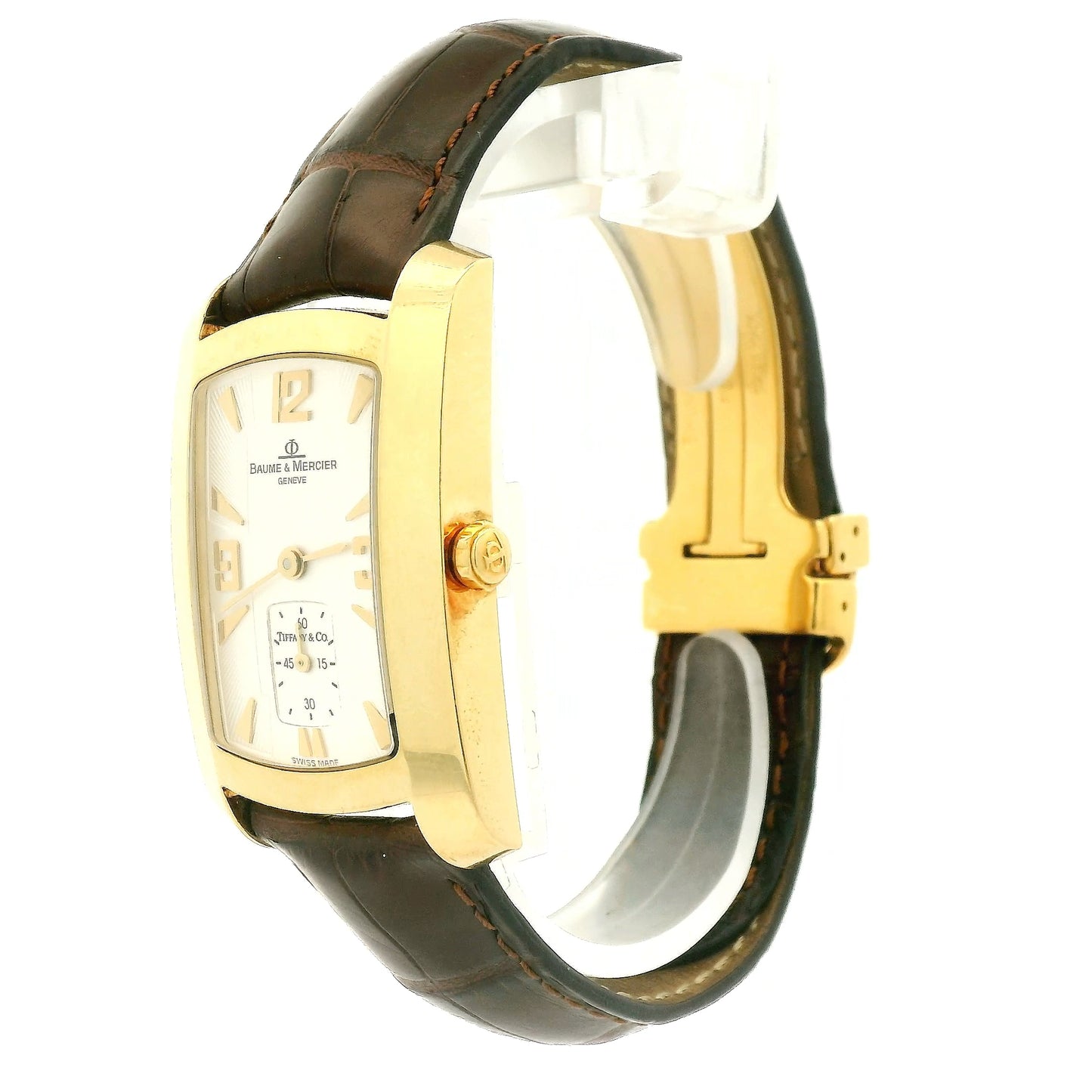 A Vintage Baume & Mercier watch with a 18k gold rectangular case, cream dial with 9, 12 & 3 displayed, the dial is stamped with a tiffany & Co., and dark brown leather strap, shown against a plain white background at Forever Rox Fine Jewelry, Lake Tahoes Best Jewelry Store