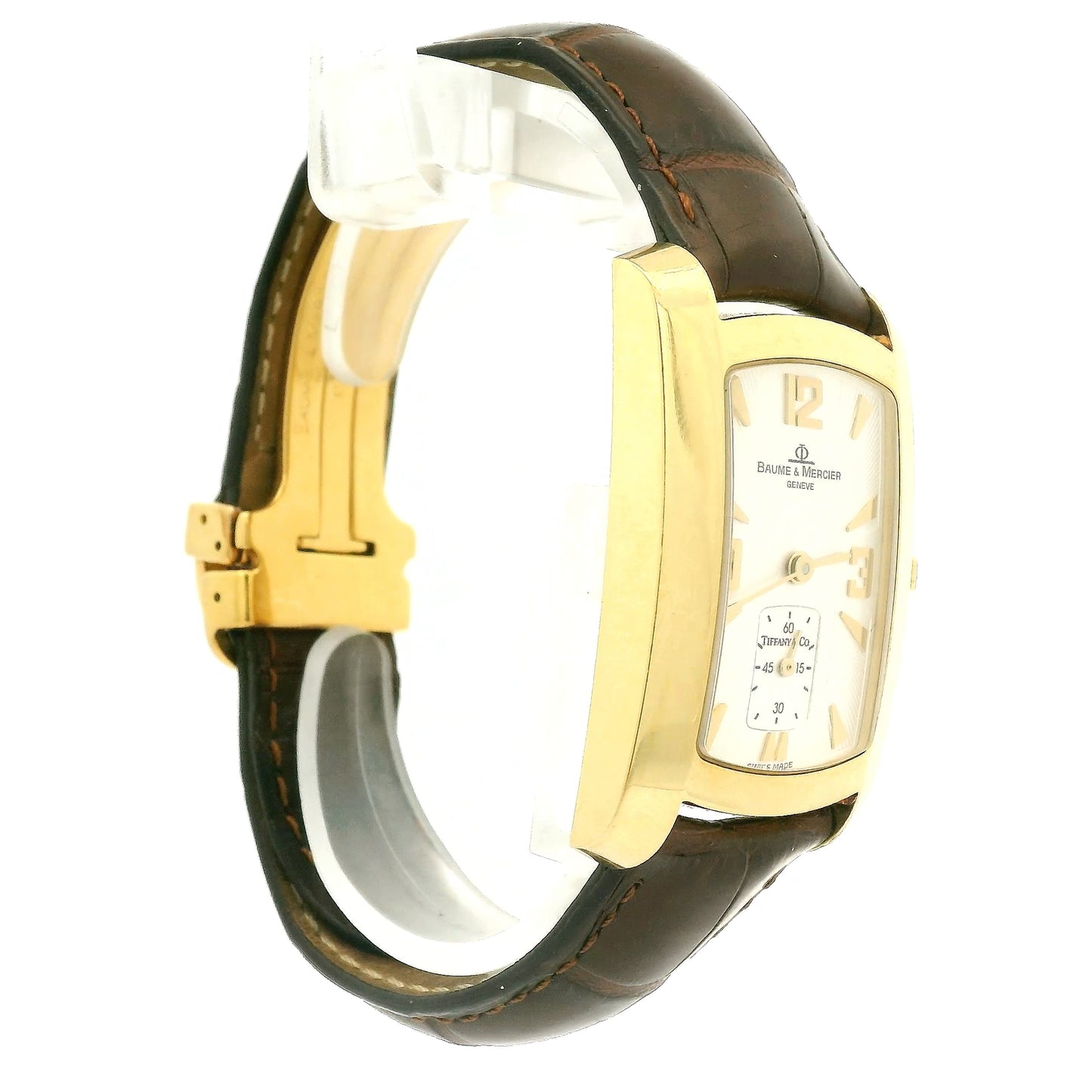 A Vintage Baume & Mercier watch with a 18k gold rectangular case, cream dial with 9, 12 & 3 displayed, the dial is stamped with a tiffany & Co., and dark brown leather strap, shown against a plain white background at Forever Rox Fine Jewelry, Lake Tahoes Best Jewelry Store
