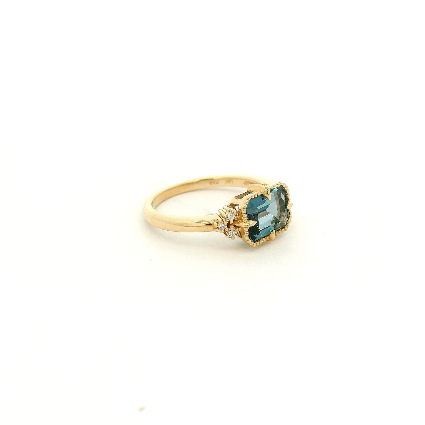 A Yellow Gold Ring with a milgrain bezel set & claw rong emerald cut natural London BLue Topaz in the center with diamonds scattered at Forever Rox Fine Jewelry, Lake Tahoes Best Jewelry Store
