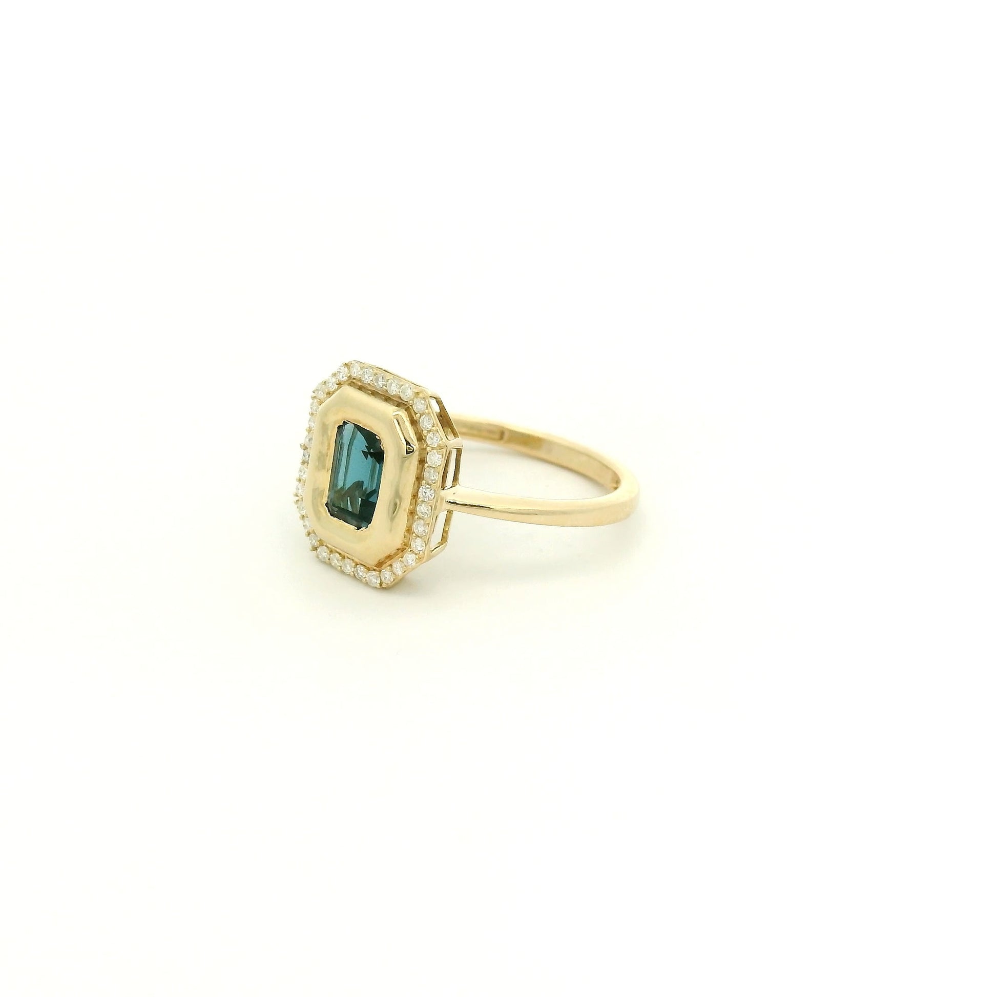 A Yellow Gold Ring with a bezel set emerald cut natural London Blue Topaz in the center with diamonds around the outside at Forever Rox Fine Jewelry, Lake Tahoes Best Jewelry Store
