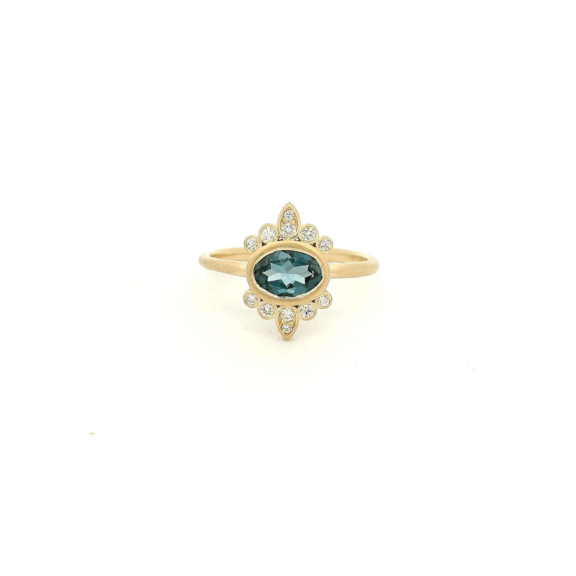 A Yellow Gold Ring with a bezel set oval cut natural London Blue Topaz in the center with diamond bursts at Forever Rox Fine Jewelry, Lake Tahoes Best Jewelry Store

