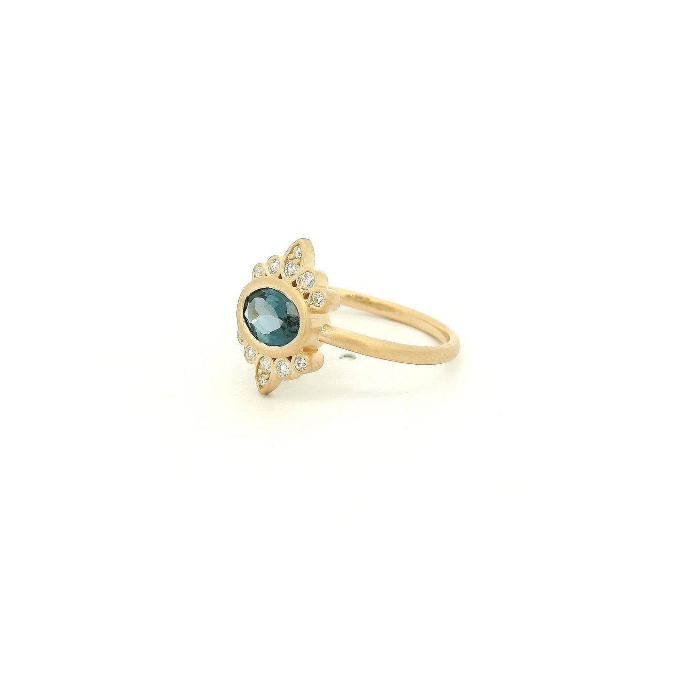 A Yellow Gold Ring with a bezel set oval cut natural London Blue Topaz in the center with diamond bursts at Forever Rox Fine Jewelry, Lake Tahoes Best Jewelry Store
