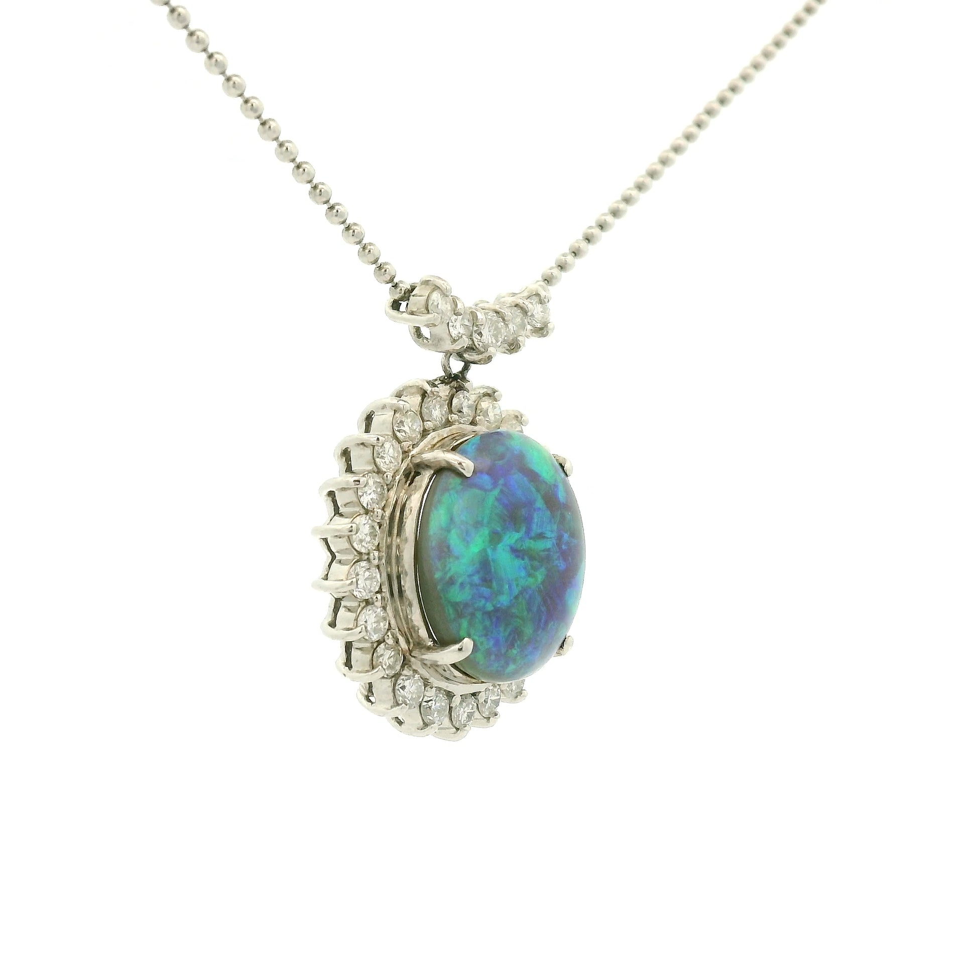 A Platinum Pendant with a prong set round cut natural Black Lightning Ridge Opal in the center with a halo of diamonds around it at Forever Rox Fine Jewelry, Lake Tahoes Best Jewelry Store