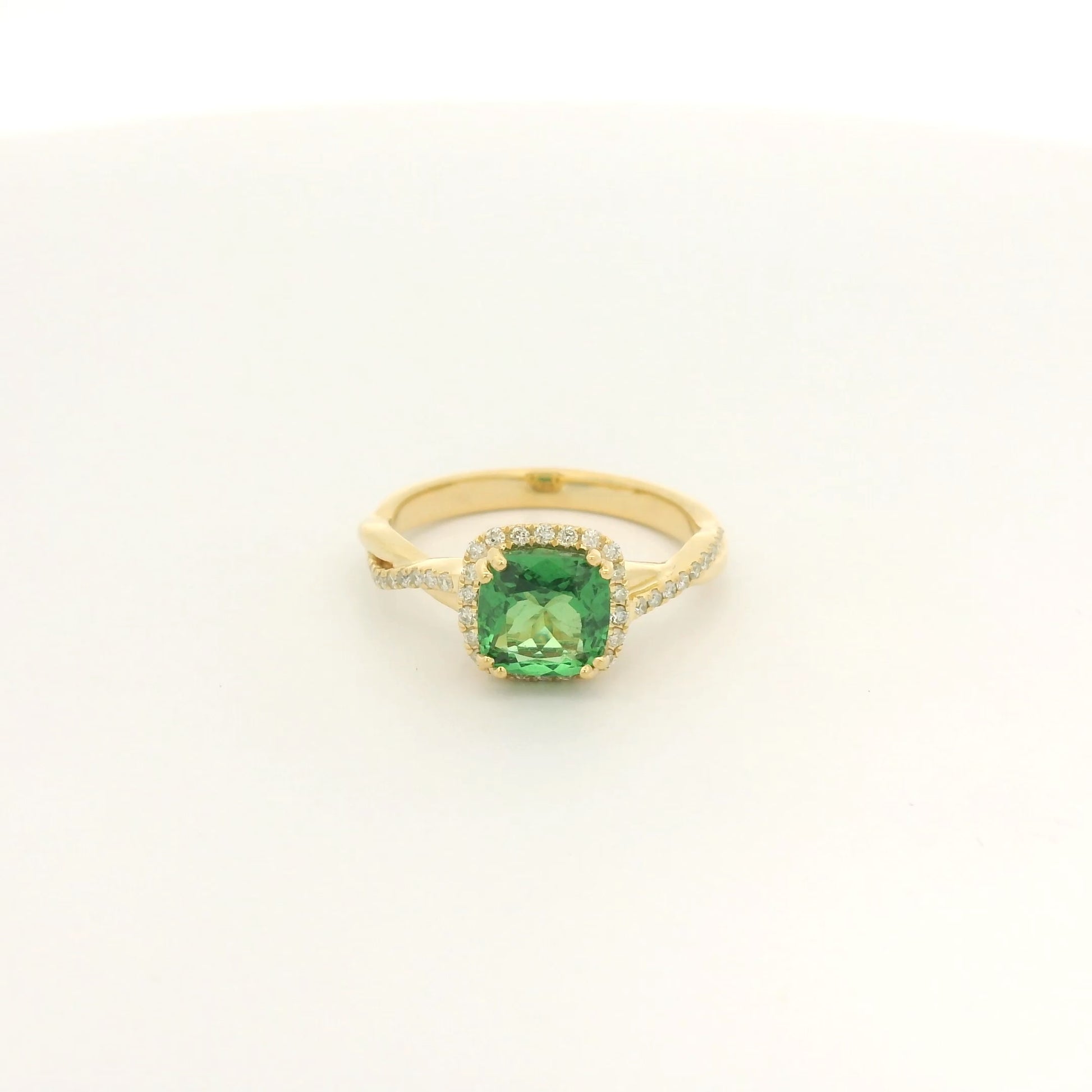 A Yellow Gold Crossover Ring with a prong set cushion cut natural Tsavorite in the center with a halo of diamonds and diamonds down shank at Forever Rox Fine Jewelry, Lake Tahoes Best Jewelry Store