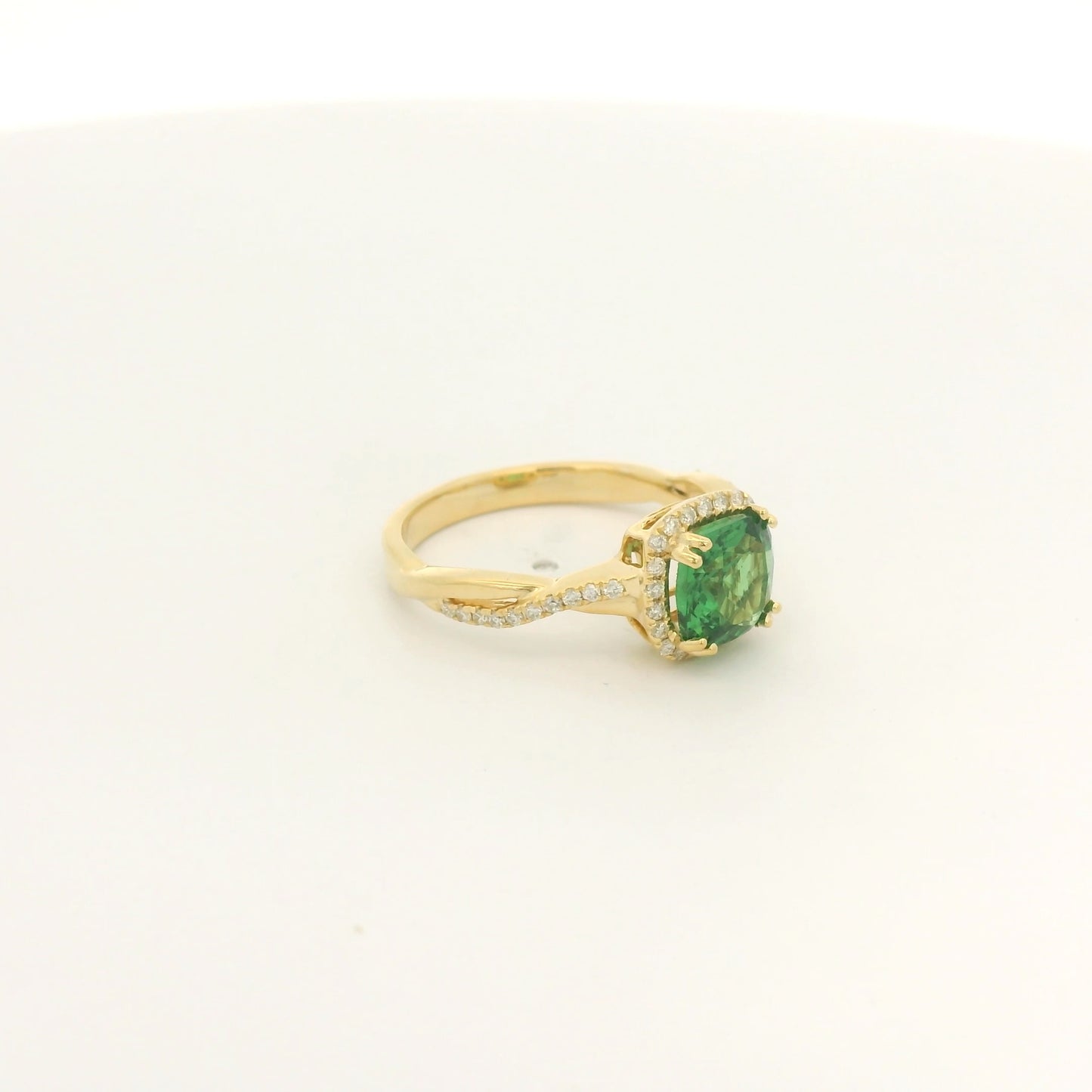 A Yellow Gold Crossover Ring with a prong set cushion cut natural Tsavorite in the center with a halo of diamonds and diamonds down shank at Forever Rox Fine Jewelry, Lake Tahoes Best Jewelry Store