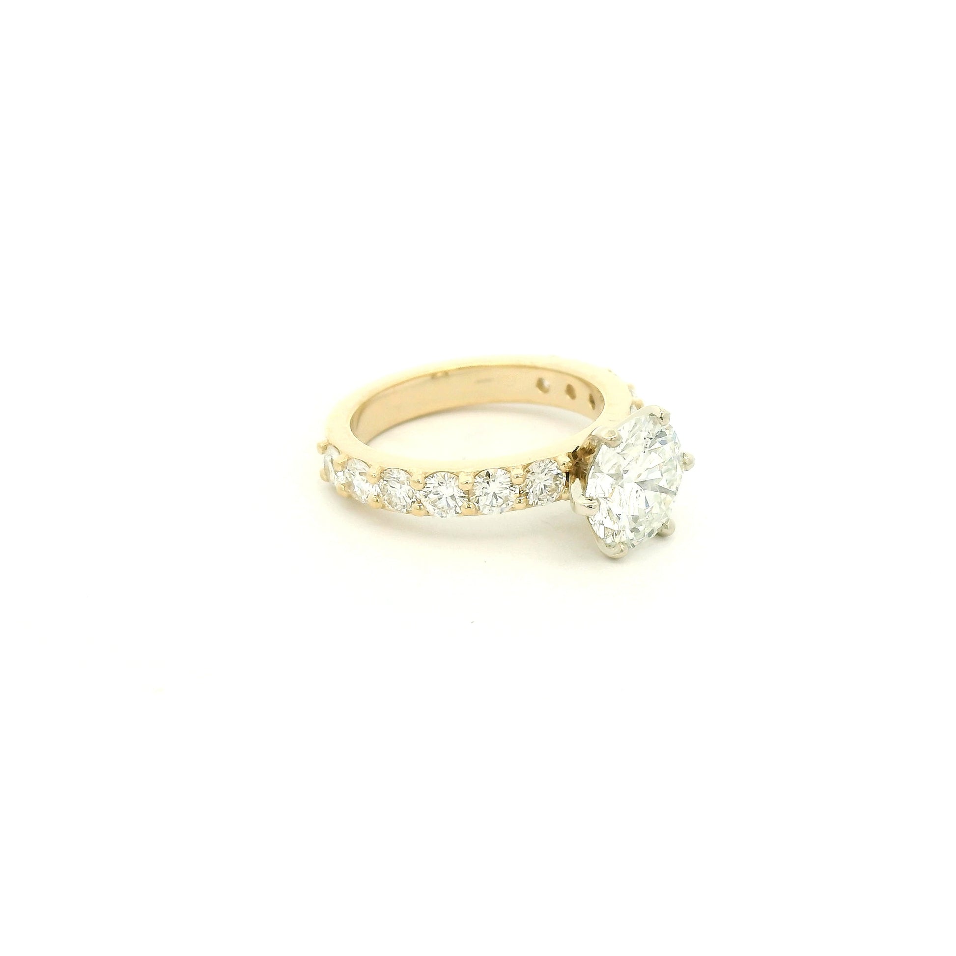 This custom 14k yellow gold engagement ring was designed around a client’s treasured diamond, creating a one-of-a-kind heirloom to be cherished for generations. The stunning 2.05 carat round brilliant cut natural diamond was professionally GIA graded as F color, VS1 clarity, and Excellent cut, polish, and symmetry (Triple Excellent) before being set into its custom-made mounting. Framing the center stone are 1.30 total carats of natural diamonds flowing down the substantial 3mm-wide band, adding brilliance 