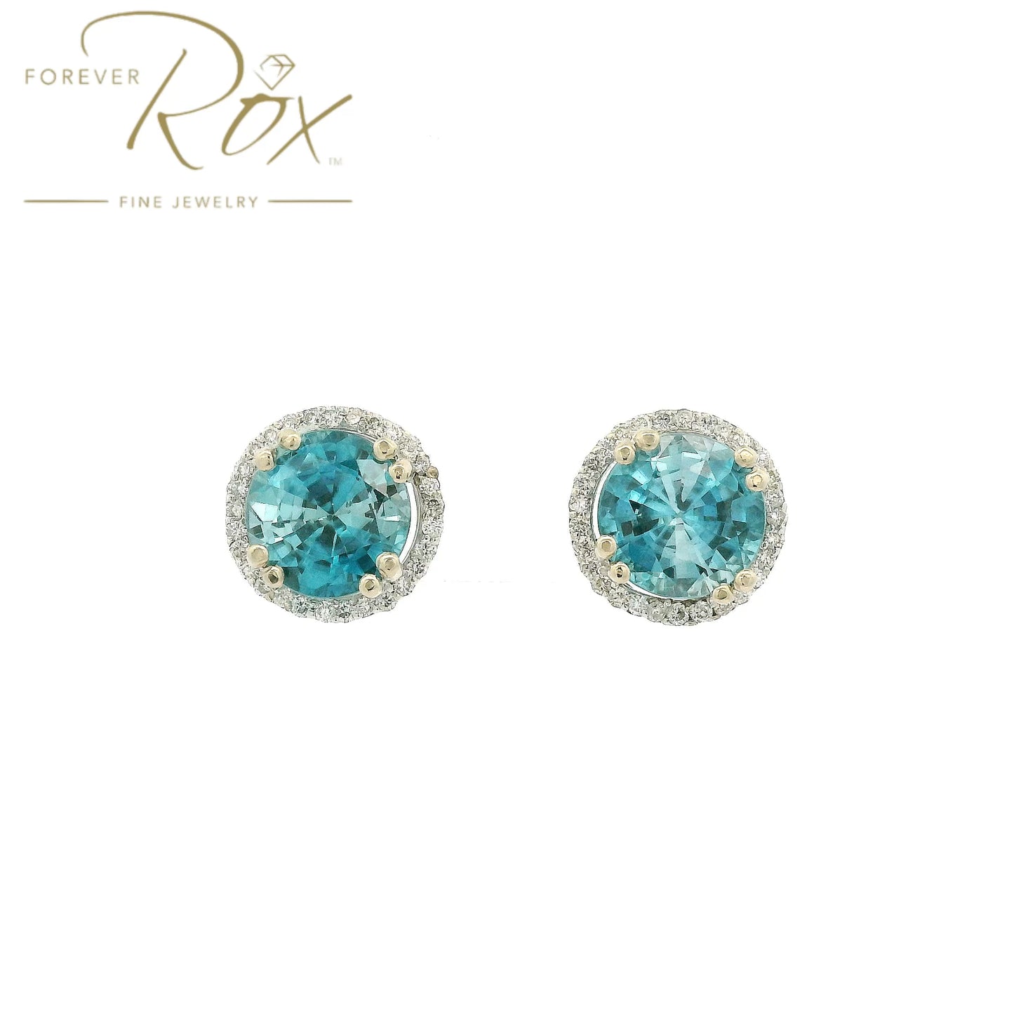A Pair of White Gold Earrings with prong set round cut natural Blue Zircon in the center with a diamond halo at Forever Rox Fine Jewelry, Lake Tahoes Best Jewelry Store