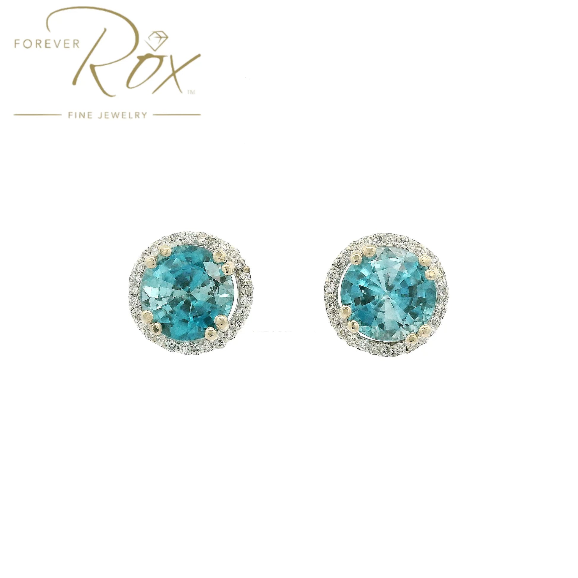 A Pair of White Gold Earrings with prong set round cut natural Blue Zircon in the center with a diamond halo at Forever Rox Fine Jewelry, Lake Tahoes Best Jewelry Store