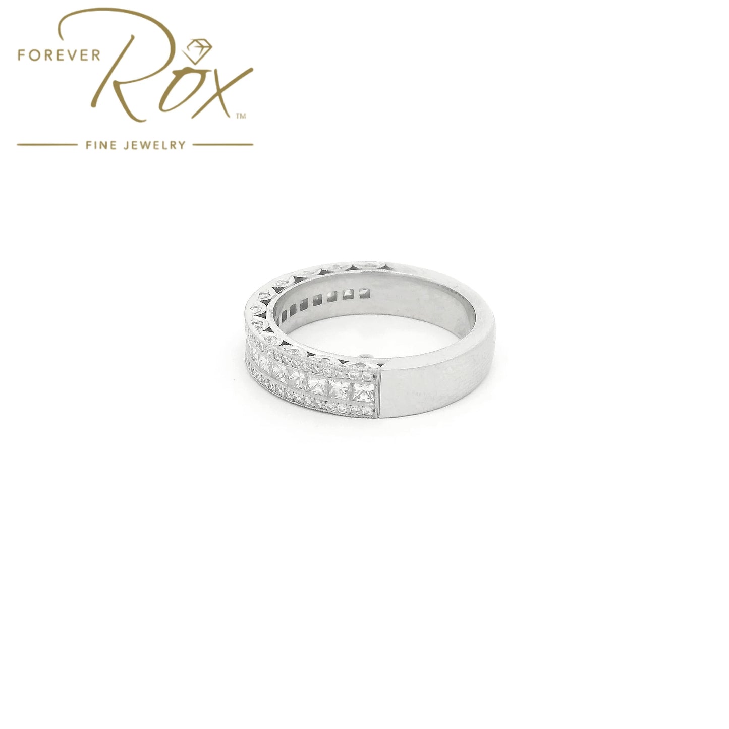 This custom platinum diamond band was designed to perfectly complement a client’s original ring that we previously created for her. The center features a row of channel-set princess-cut diamonds, framed above and below by channel-set round brilliant diamonds for added sparkle. Intricate filigree detailing along the edges was carefully incorporated to match the design of her original ring, creating a cohesive, one-of-a-kind set made especially for her.