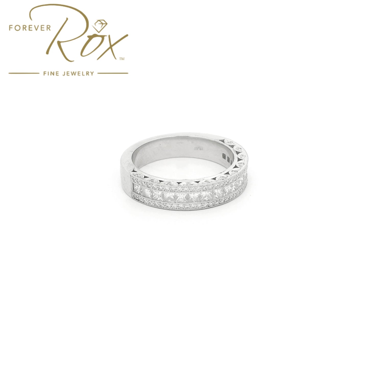 This custom 14k white gold diamond band was designed to perfectly complement a client’s original ring that we previously created for her. The center features a row of channel-set princess-cut diamonds, framed above and below by channel-set round brilliant diamonds for added sparkle. Intricate filigree detailing along the edges was carefully incorporated to match the design of her original ring, creating a cohesive, one-of-a-kind set made especially for her.