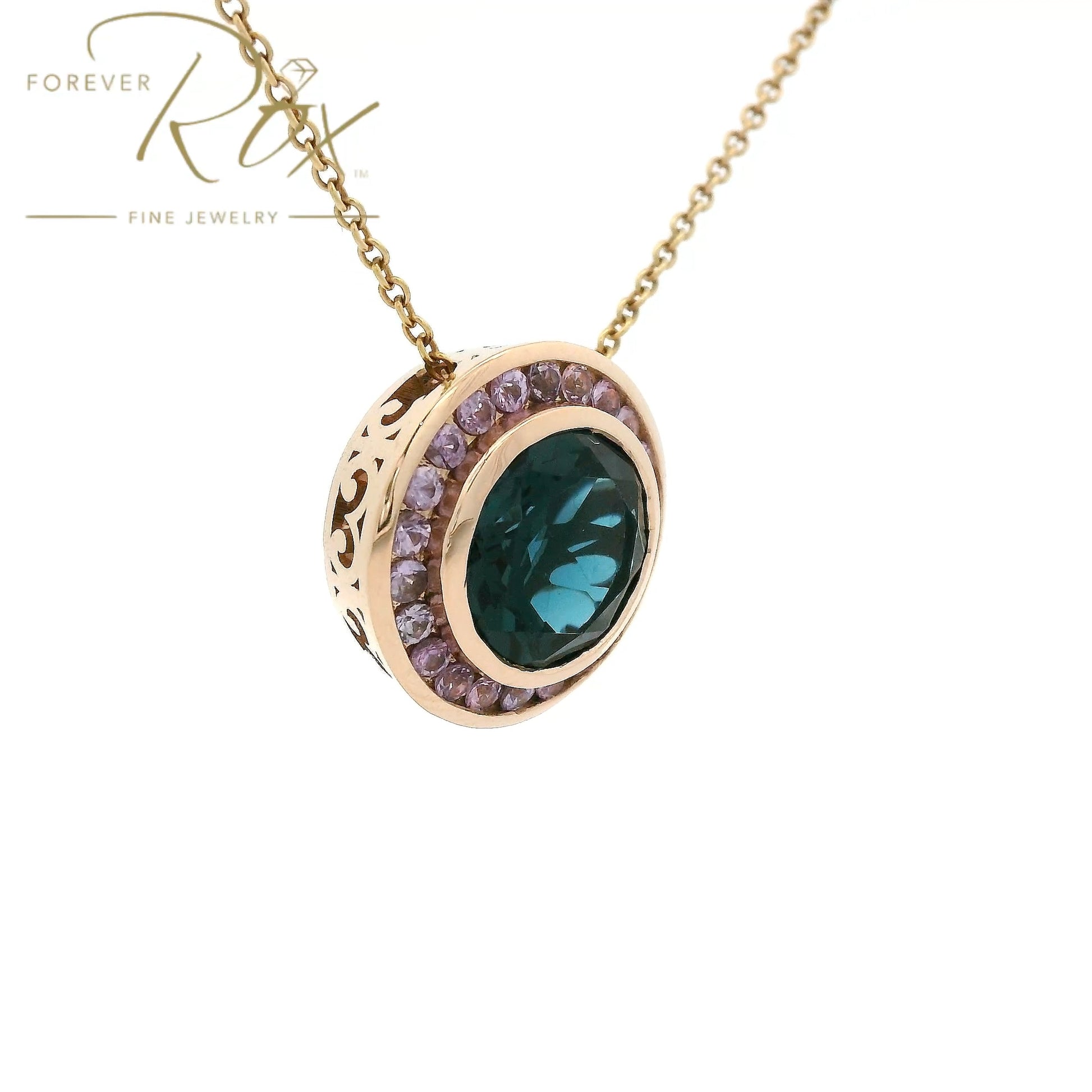 A striking 4.31ct round-cut London Blue Topaz takes center stage in this custom 14k rose gold pendant, framed by a delicate halo of light purple sapphires for an unexpected pop of color. Crafted to complement a client's existing ring, the warm rose gold setting reveals an intricate filigree gallery along its sides — a hidden detail that elevates every angle. Bold yet refined, it's a modern heirloom designed to be worn and treasured.