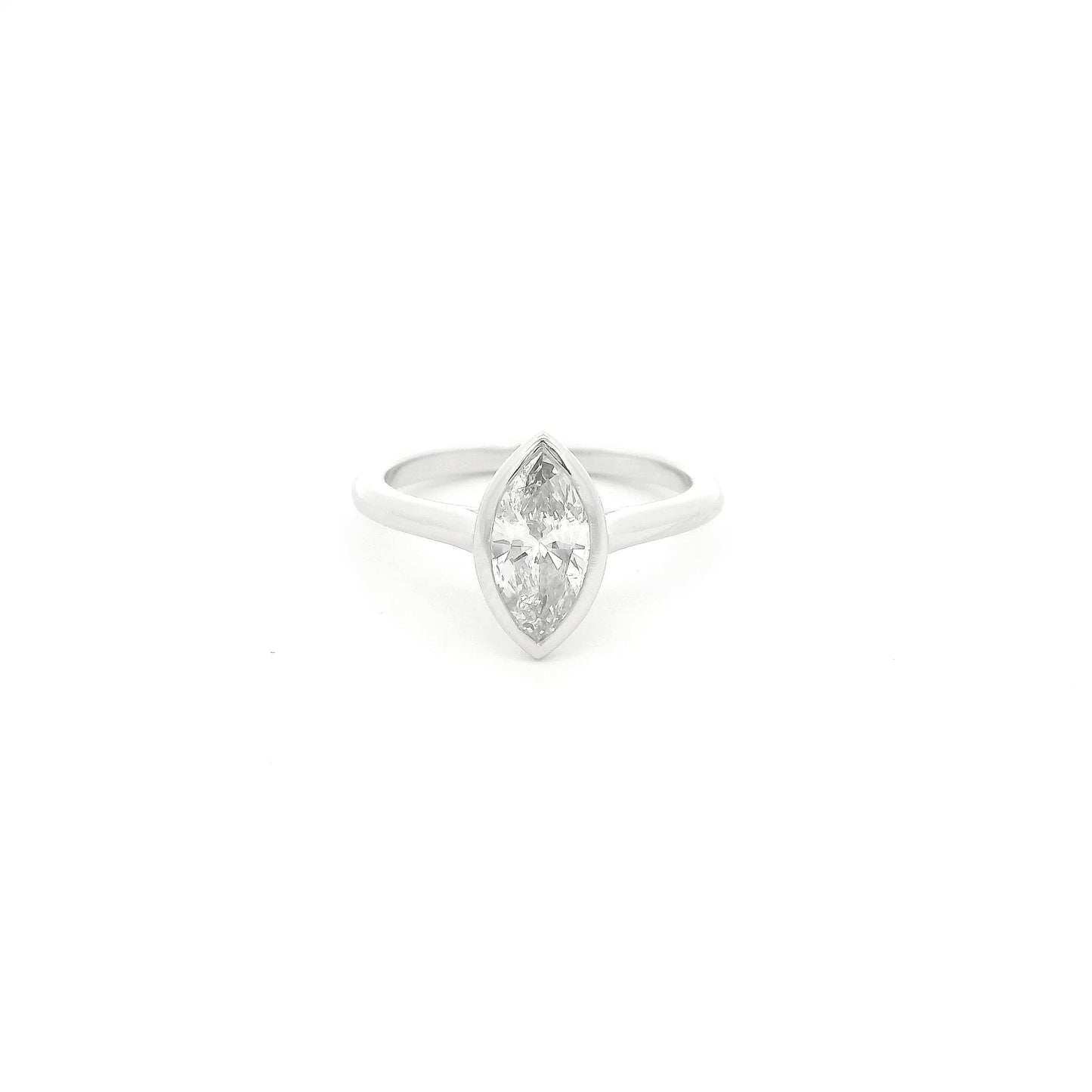 This custom ring showcases a stunning 1.04 carat natural marquise cut diamond elegantly bezel set in platinum. Designed with clean lines and a delicate, flowing band, the minimalist setting allows the diamond’s graceful silhouette to take center stage while offering exceptional security and everyday wearability. A timeless custom design that perfectly balances modern simplicity with the enduring beauty of a natural diamond.