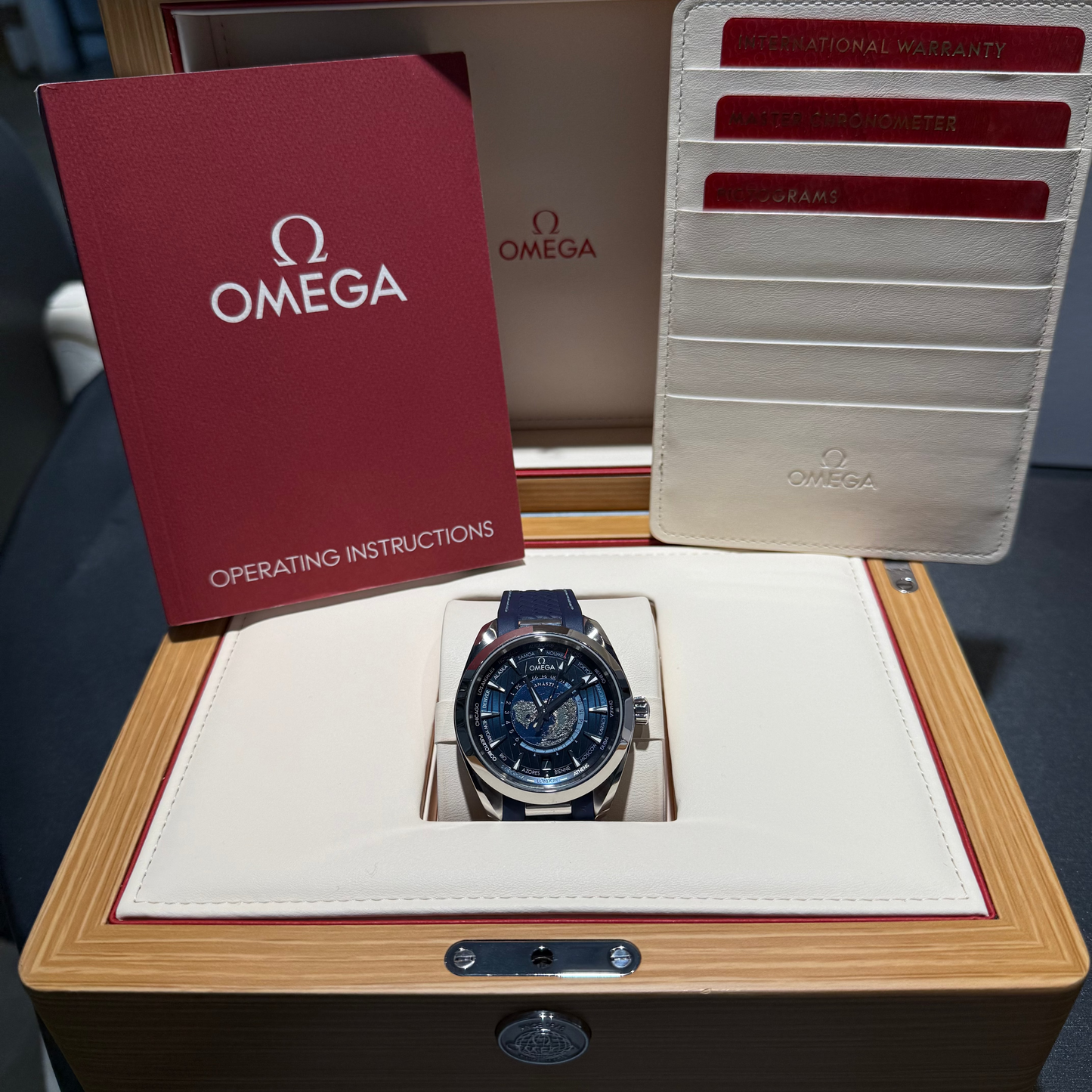 Omega watch in a wooden box with operating instructions and cards