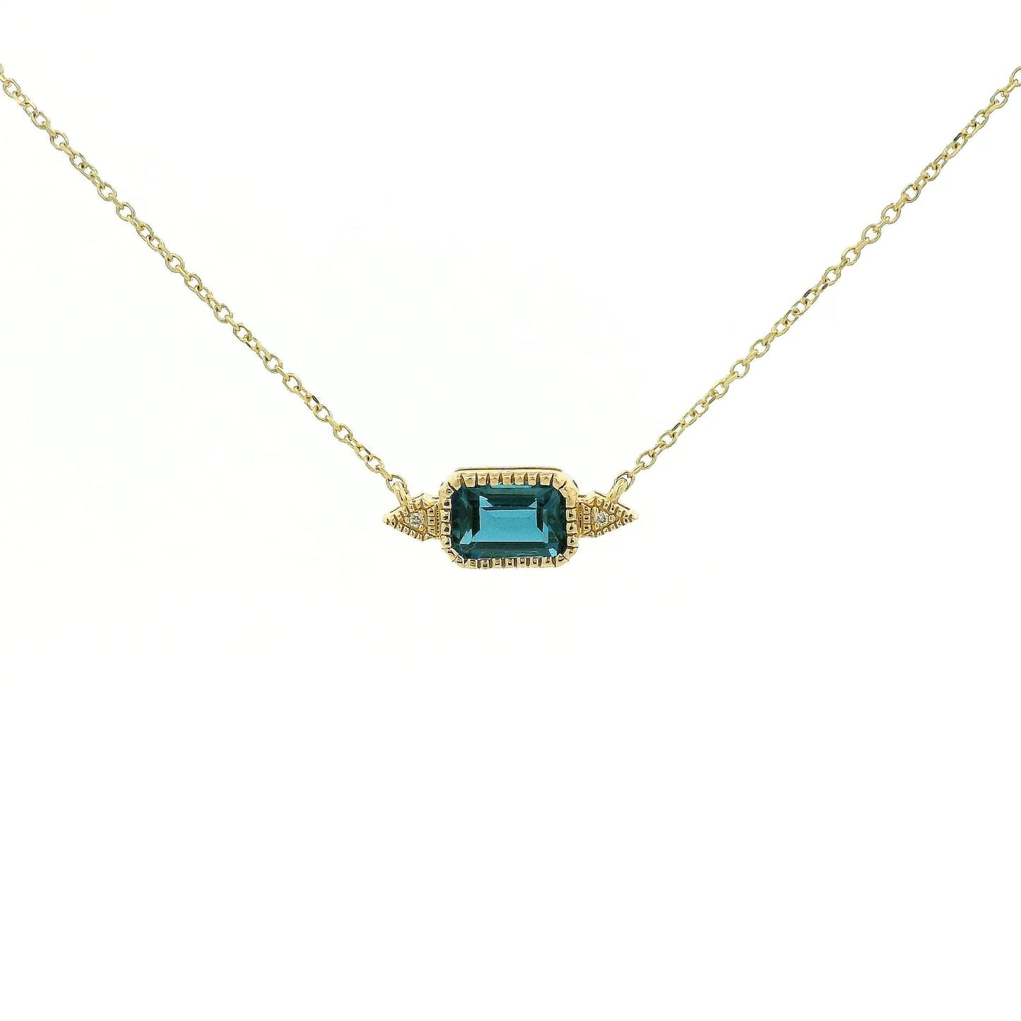 A Yellow Gold Pendant with a milgrain bezel set emerald cut natural London Blue Topaz in the center with 2 diamonds and a chain attached at Forever Rox Fine Jewelry, Lake Tahoes Best Jewelry Store