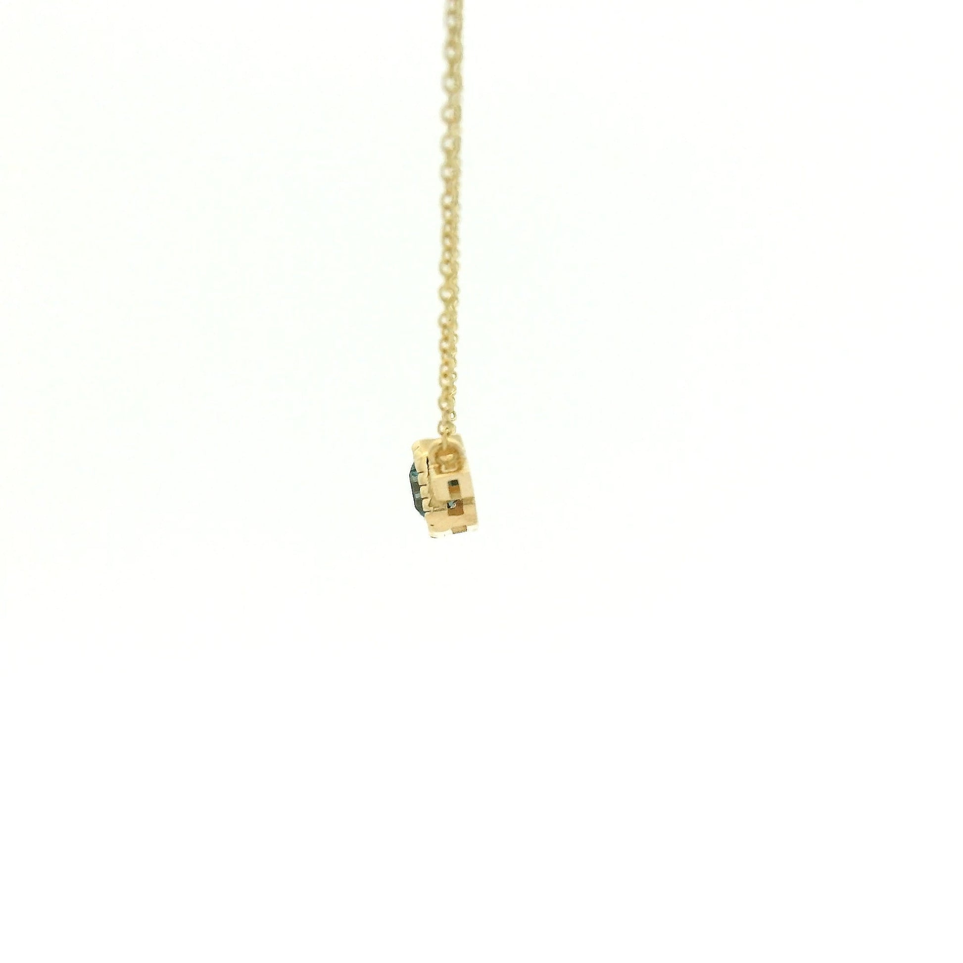 A Yellow Gold Pendant with a milgrain bezel set emerald cut natural London Blue Topaz in the center with 2 diamonds and a chain attached at Forever Rox Fine Jewelry, Lake Tahoes Best Jewelry Store