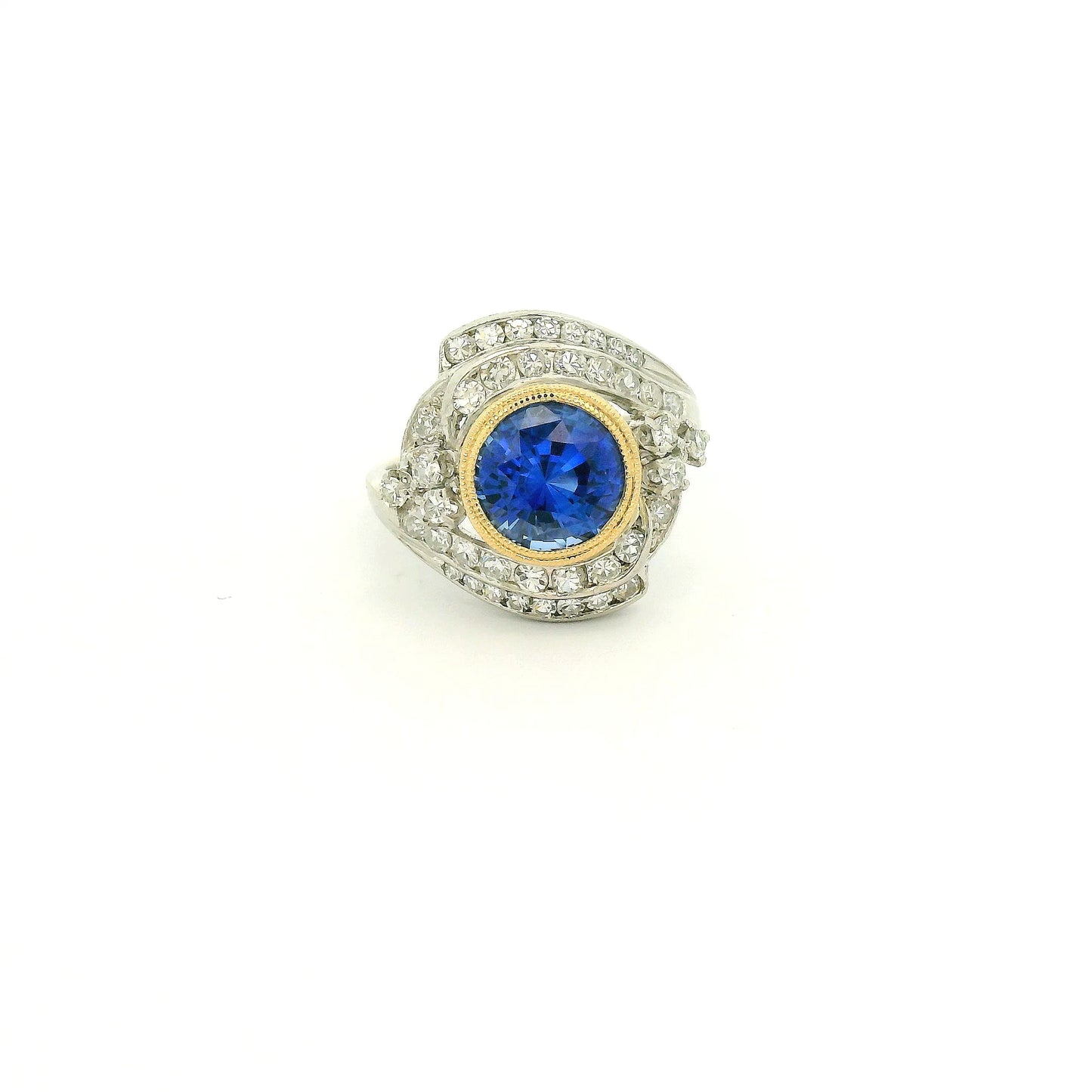 A Vintage Platinum & Yellow Gold Ring with a milgrain bezel set round cut natural Fine Blue Sapphire in the center with diamonds scattered around at Forever Rox Fine Jewelry, Lake Tahoes Best Jewelry Store
