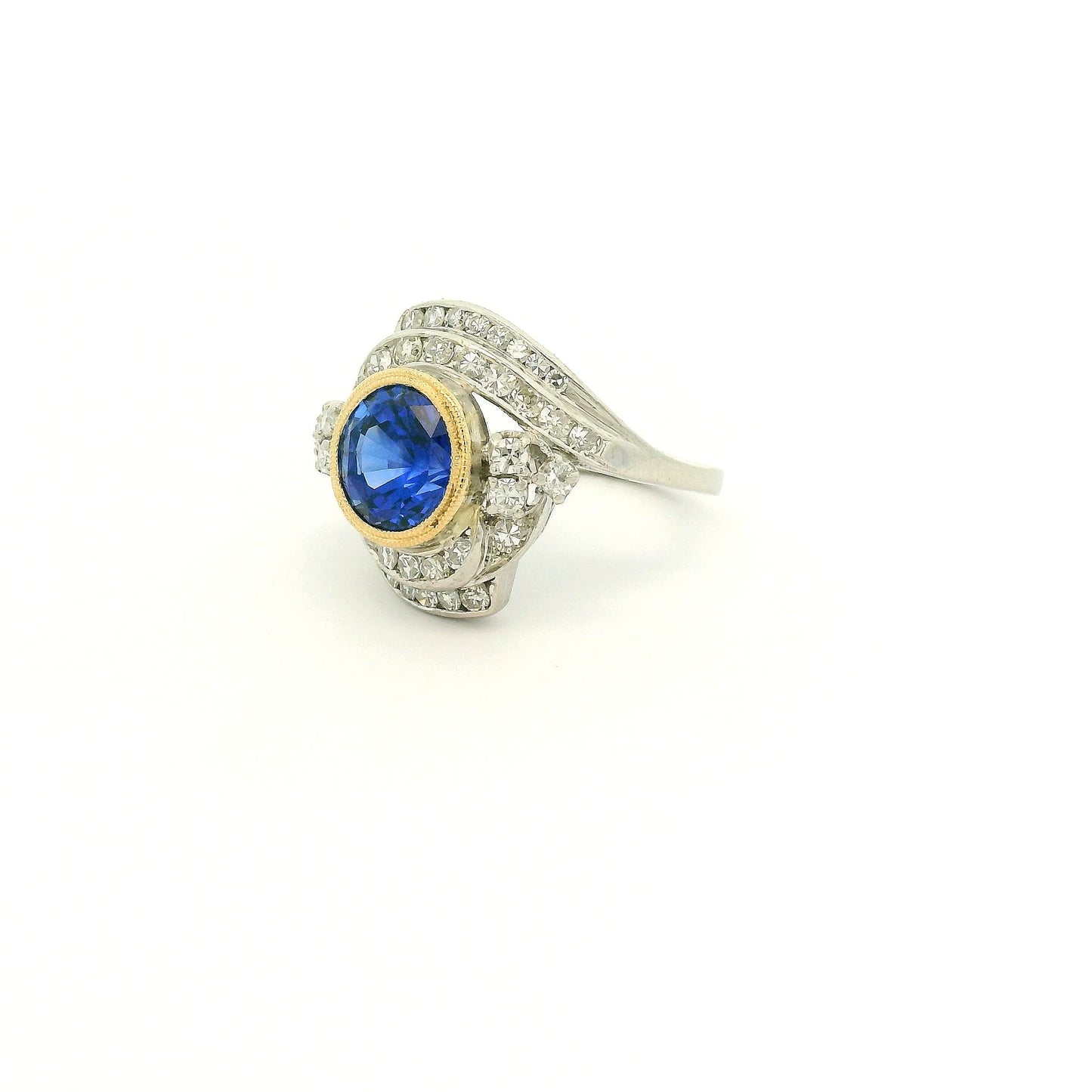 A Vintage Platinum & Yellow Gold Ring with a milgrain bezel set round cut natural Fine Blue Sapphire in the center with diamonds scattered around at Forever Rox Fine Jewelry, Lake Tahoes Best Jewelry Store