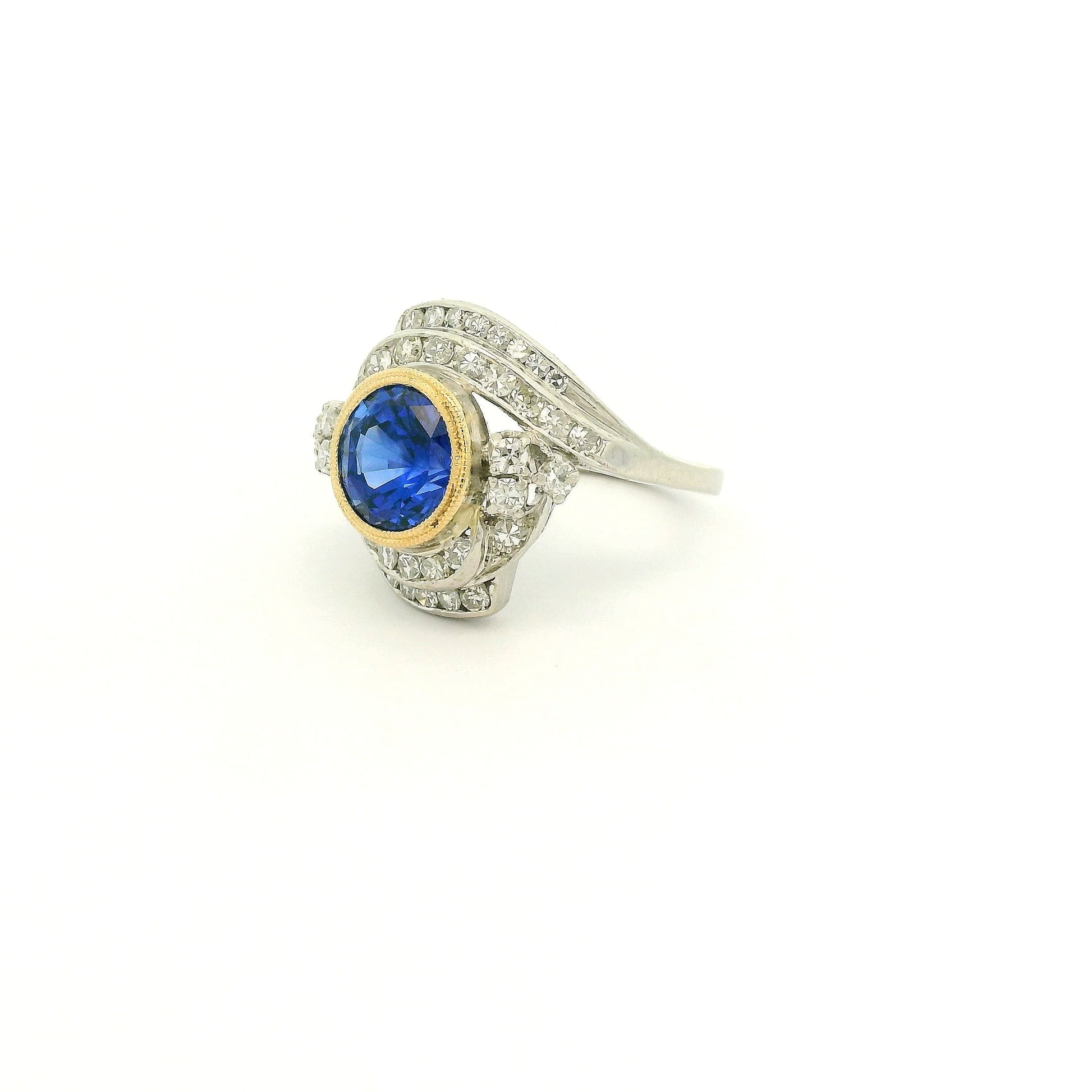 A Vintage Platinum & Yellow Gold Ring with a milgrain bezel set round cut natural Fine Blue Sapphire in the center with diamonds scattered around at Forever Rox Fine Jewelry, Lake Tahoes Best Jewelry Store