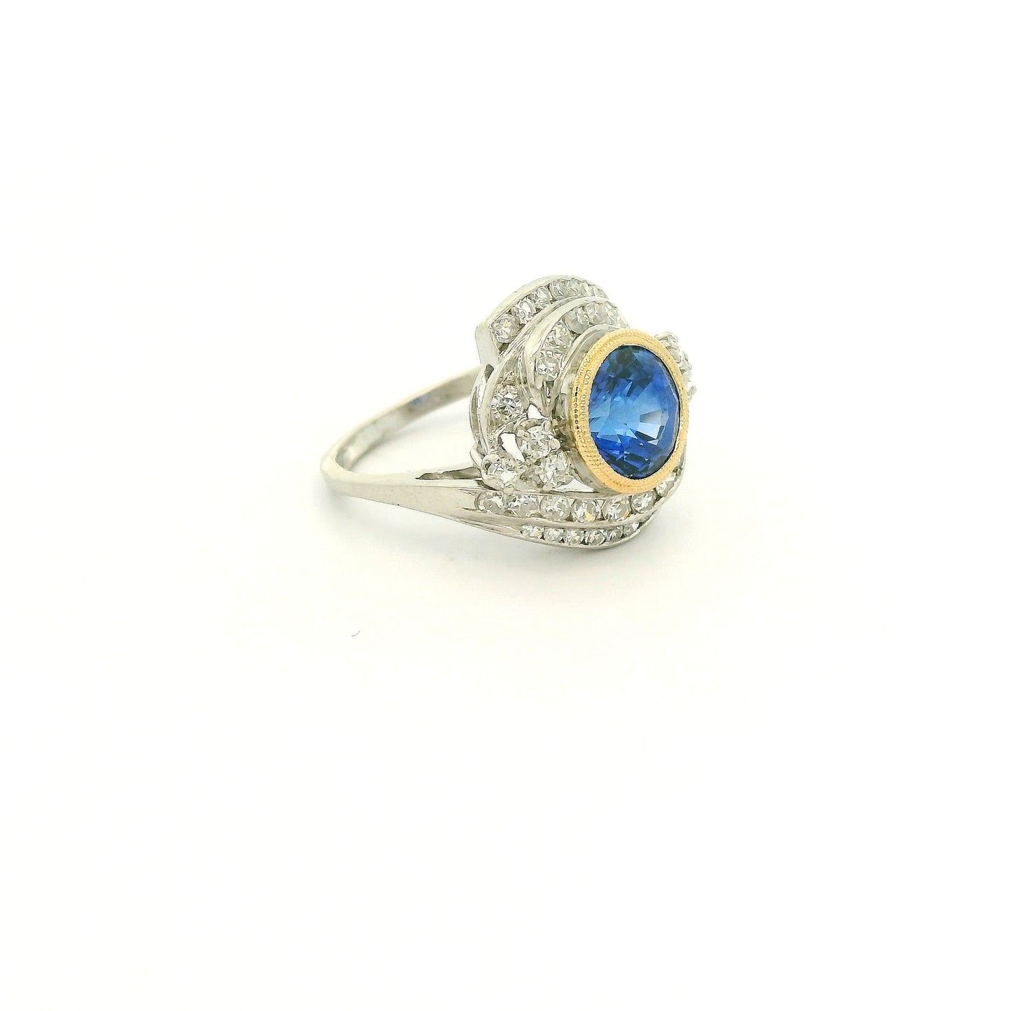 A Vintage Platinum & Yellow Gold Ring with a milgrain bezel set round cut natural Fine Blue Sapphire in the center with diamonds scattered around at Forever Rox Fine Jewelry, Lake Tahoes Best Jewelry Store
