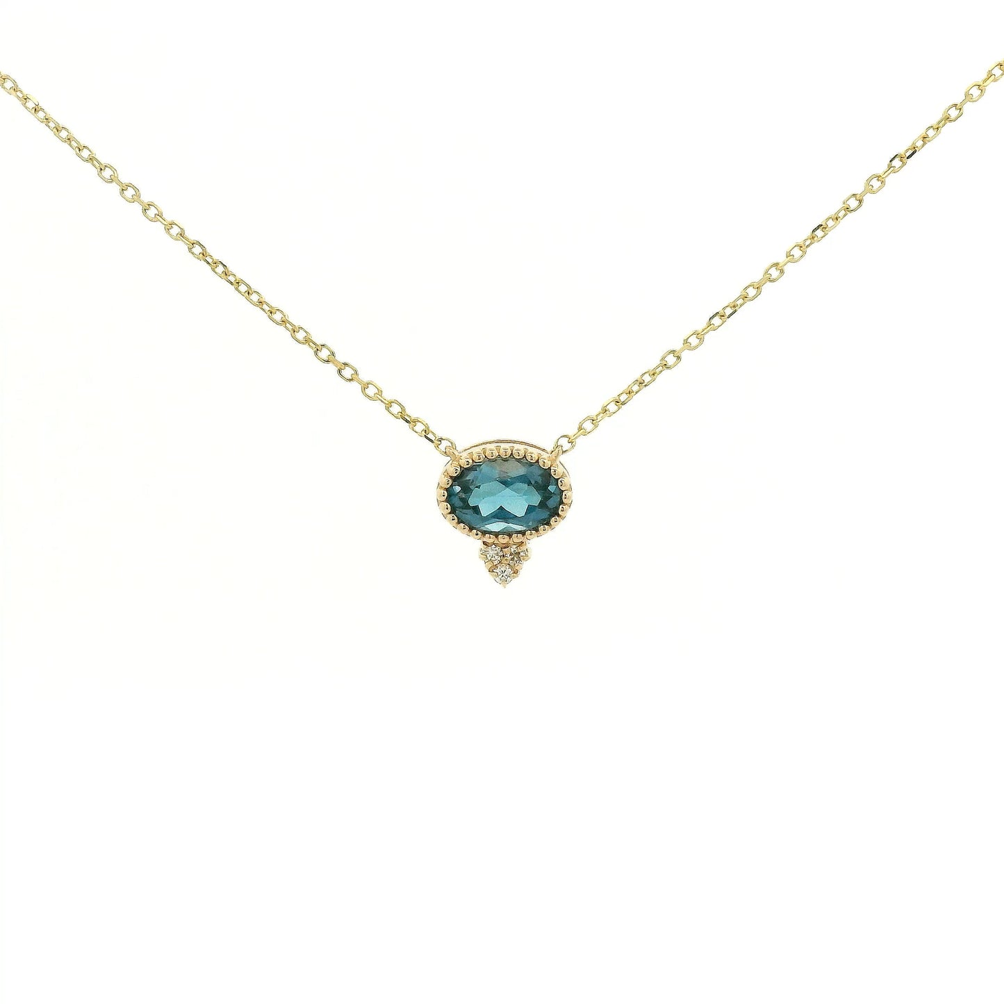 A Yellow Gold Pendant with a milgrain bezel set oval cut natural London Blue Topaz in the center with 3 diamonds and a chain attached at Forever Rox Fine Jewelry, Lake Tahoes Best Jewelry Store