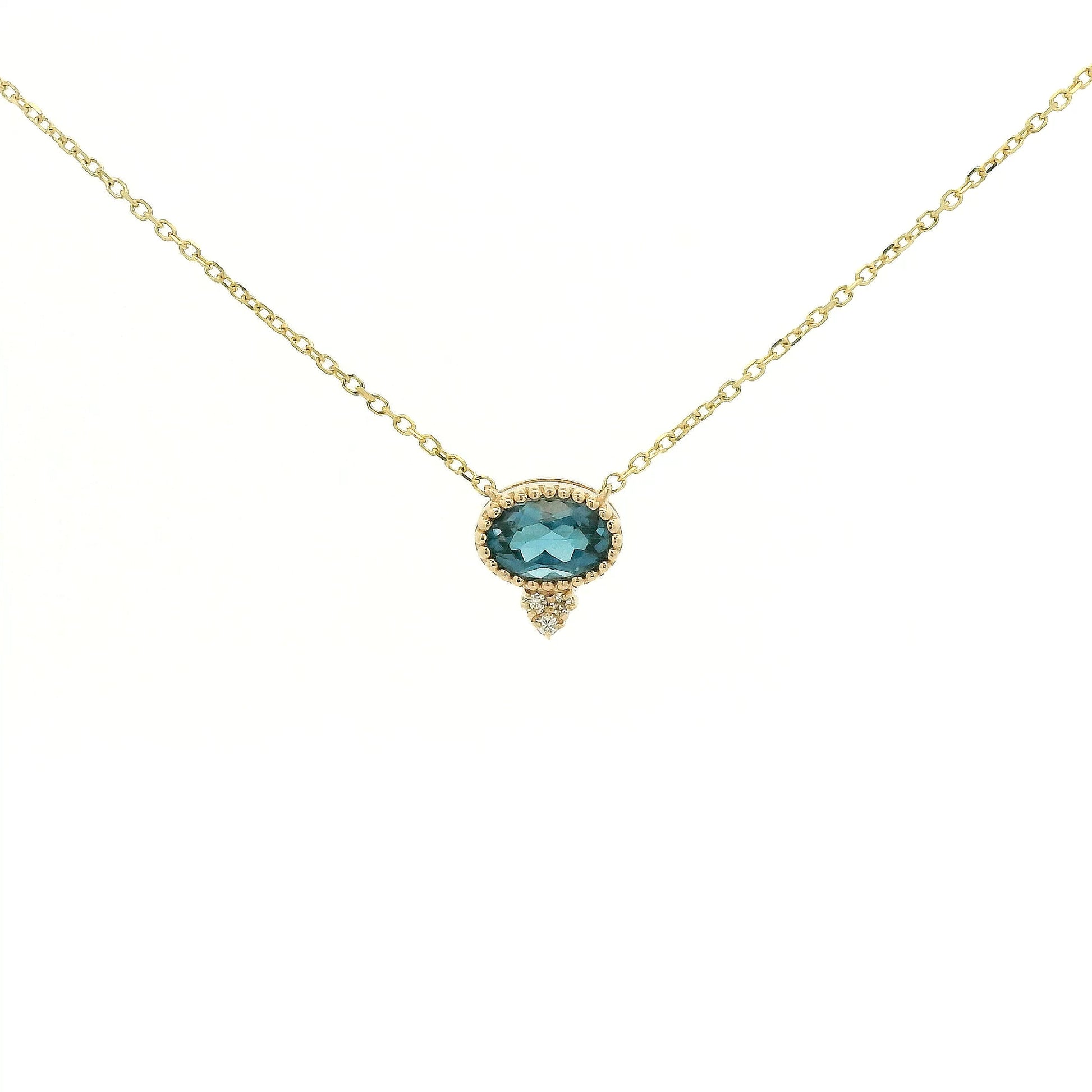 A Yellow Gold Pendant with a milgrain bezel set oval cut natural London Blue Topaz in the center with 3 diamonds and a chain attached at Forever Rox Fine Jewelry, Lake Tahoes Best Jewelry Store