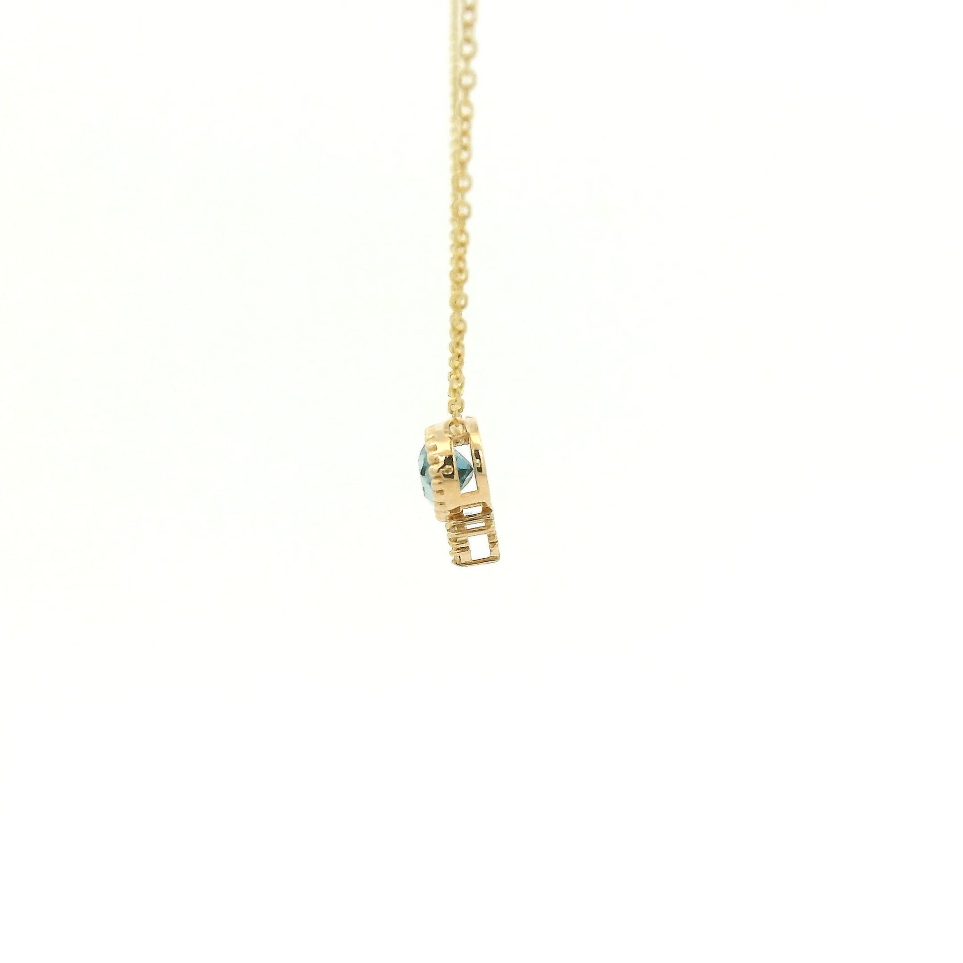 A Yellow Gold Pendant with a milgrain bezel set oval cut natural London Blue Topaz in the center with 3 diamonds and a chain attached at Forever Rox Fine Jewelry, Lake Tahoes Best Jewelry Store
