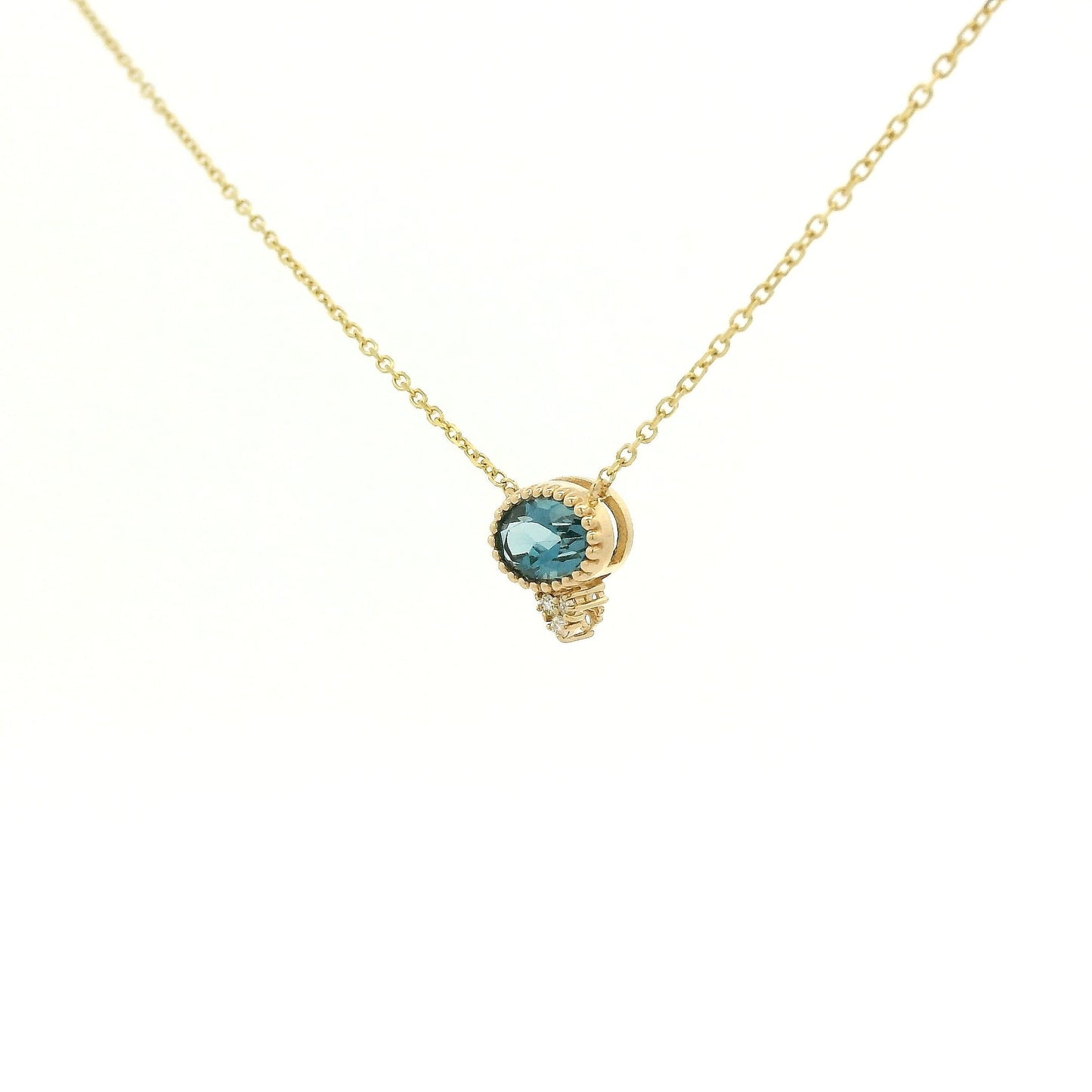 A Yellow Gold Pendant with a milgrain bezel set oval cut natural London Blue Topaz in the center with 3 diamonds and a chain attached at Forever Rox Fine Jewelry, Lake Tahoes Best Jewelry Store