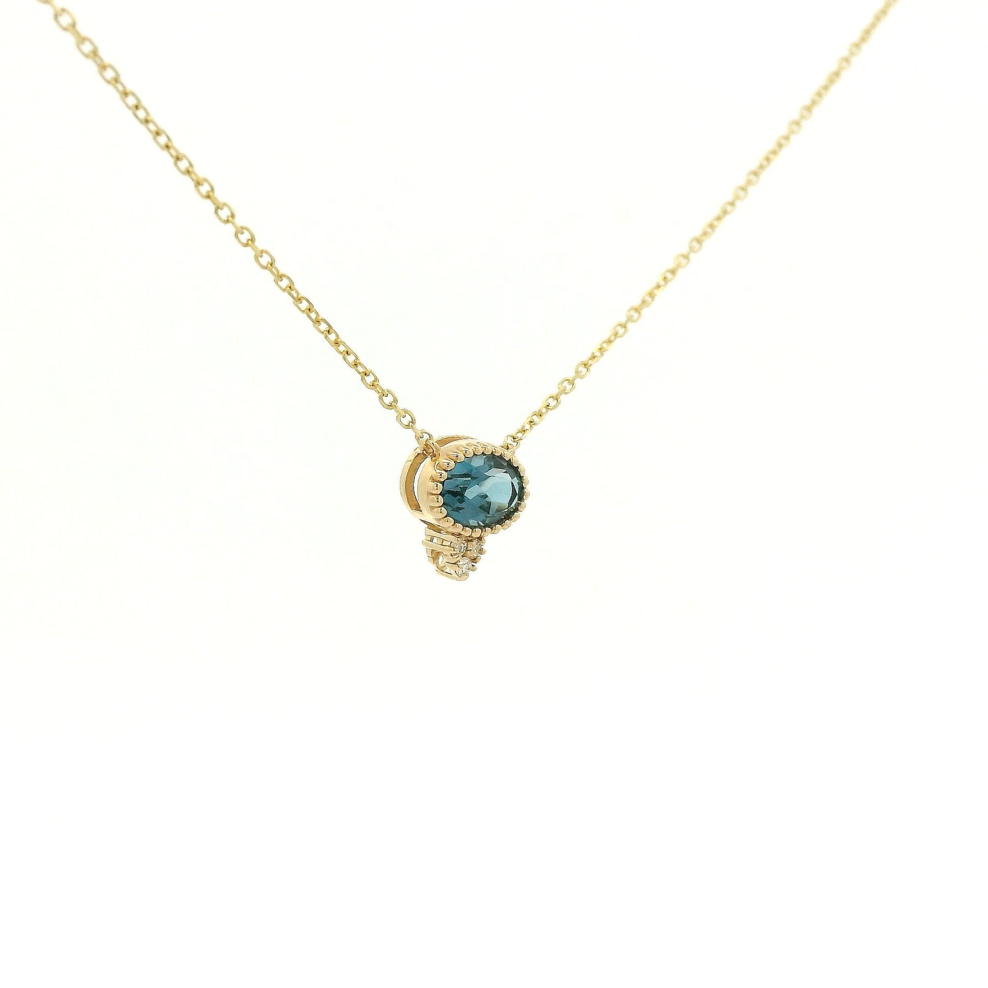 A Yellow Gold Pendant with a milgrain bezel set oval cut natural London Blue Topaz in the center with 3 diamonds and a chain attached at Forever Rox Fine Jewelry, Lake Tahoes Best Jewelry Store