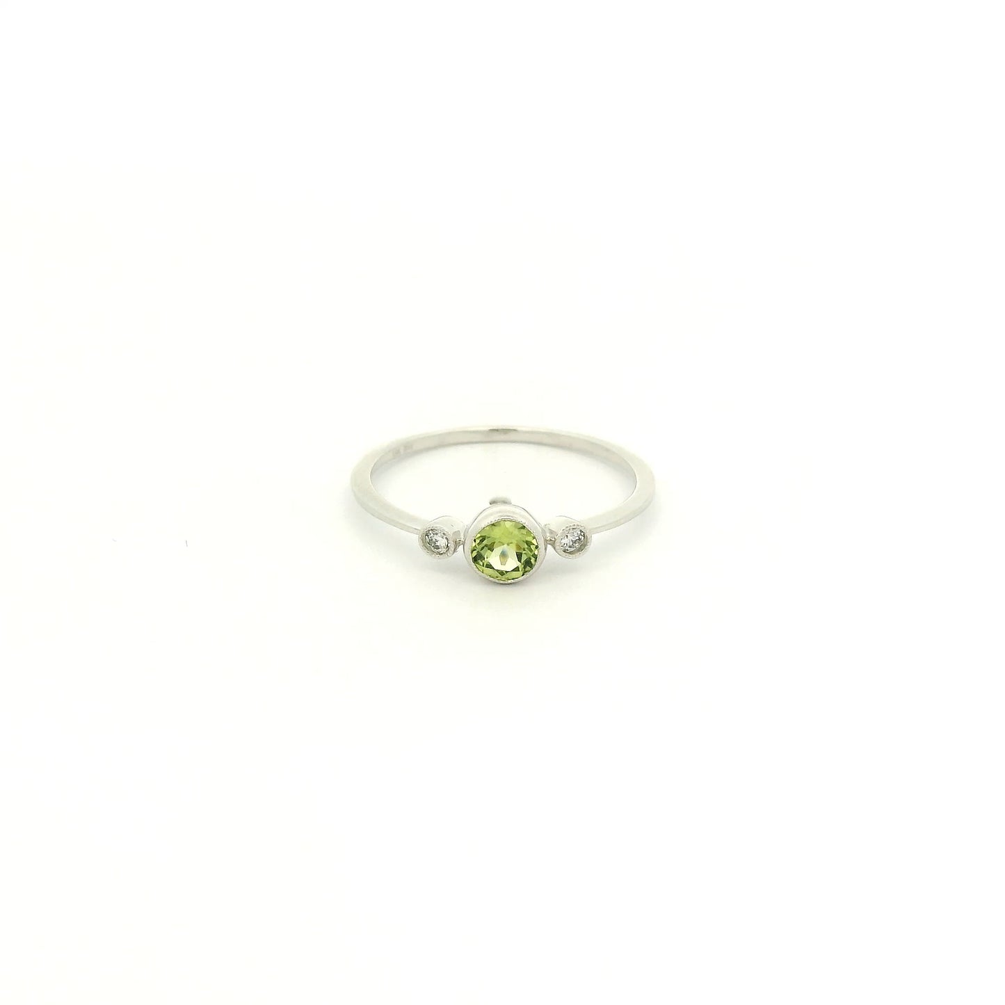 A White Gold Ring with a milgrain bezel set round cut natural Peridot in the center with 2 bezel set Natural Diamonds at Forever Rox Fine Jewelry, Lake Tahoes Best Jewelry Store
