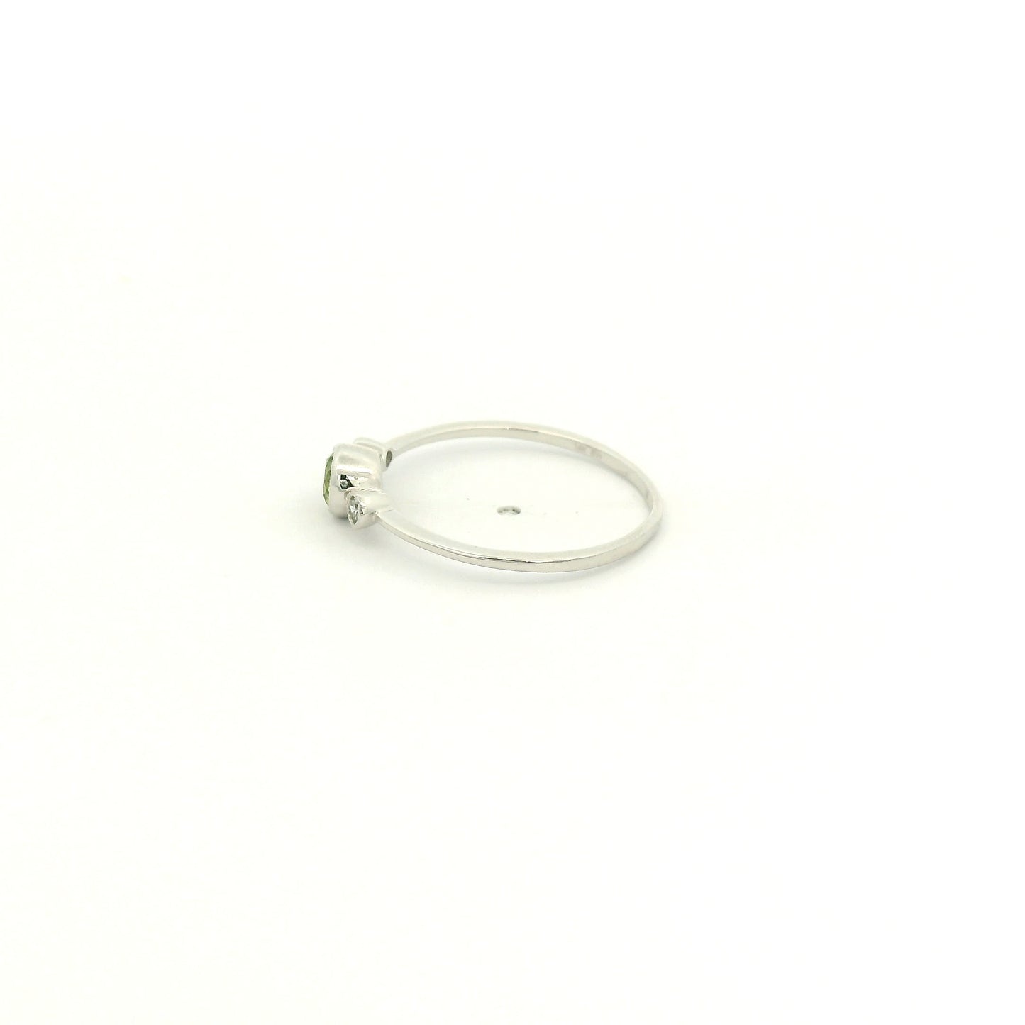 A White Gold Ring with a milgrain bezel set round cut natural Peridot in the center with 2 bezel set Natural Diamonds at Forever Rox Fine Jewelry, Lake Tahoes Best Jewelry Store

