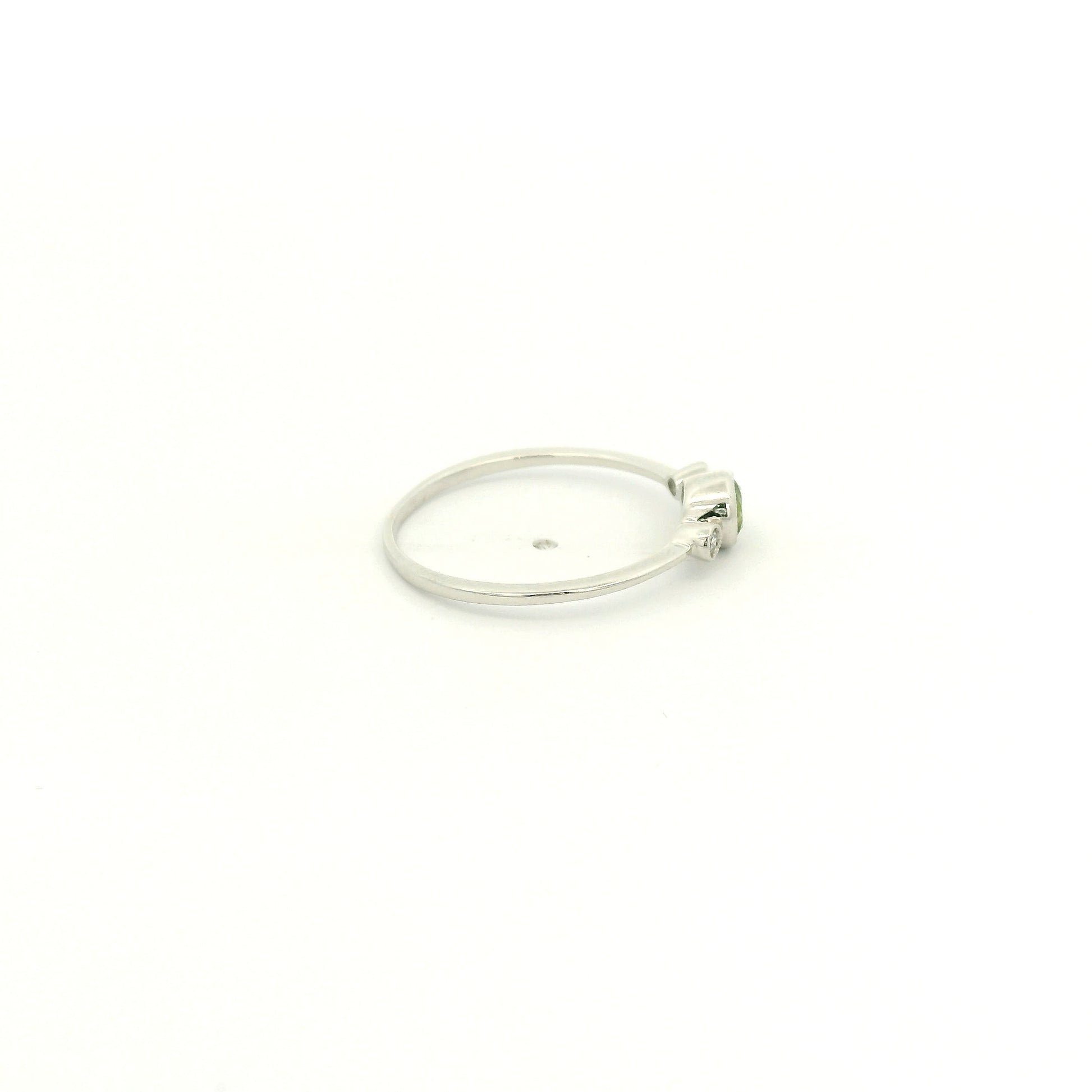 A White Gold Ring with a milgrain bezel set round cut natural Peridot in the center with 2 bezel set Natural Diamonds at Forever Rox Fine Jewelry, Lake Tahoes Best Jewelry Store
