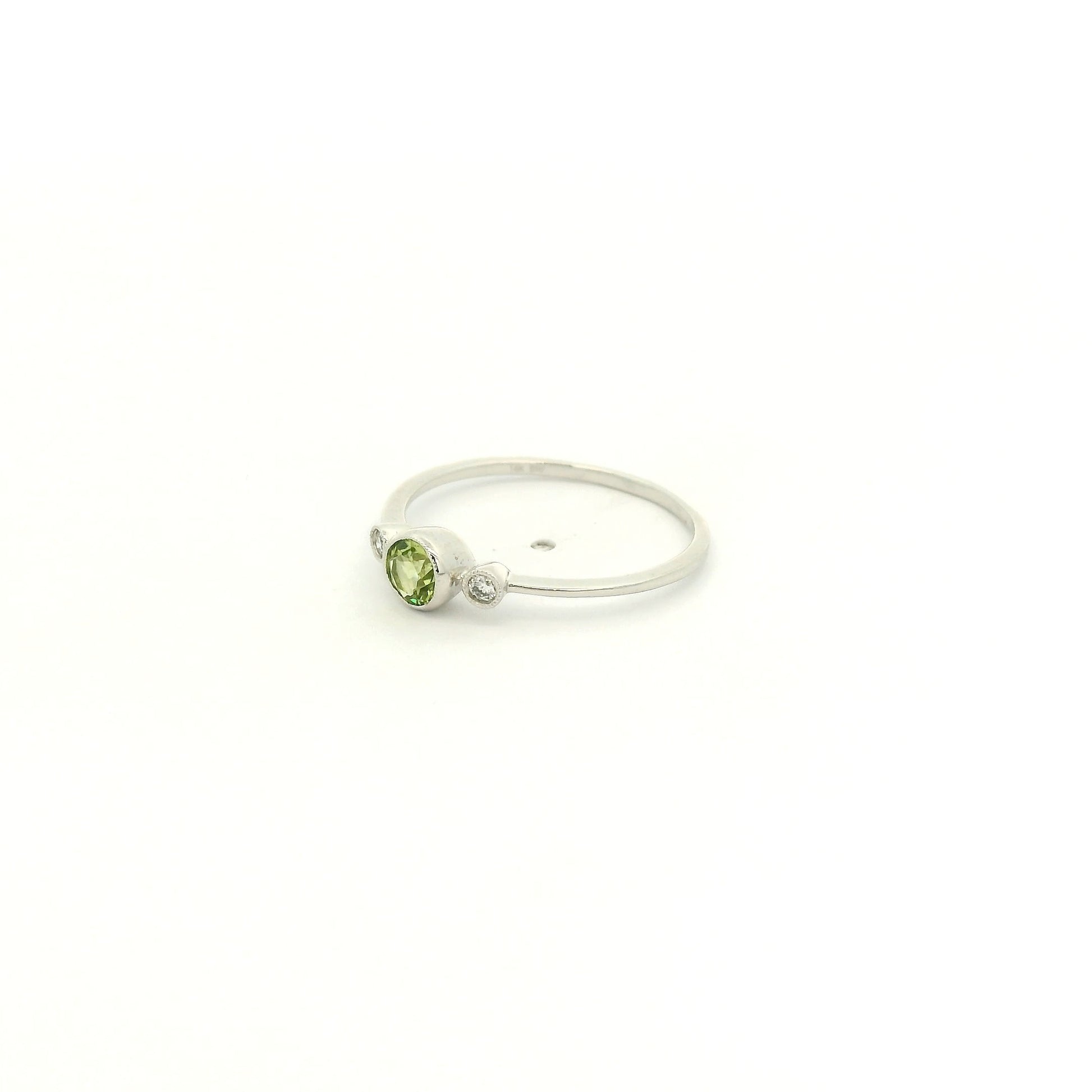 A White Gold Ring with a milgrain bezel set round cut natural Peridot in the center with 2 bezel set Natural Diamonds at Forever Rox Fine Jewelry, Lake Tahoes Best Jewelry Store
