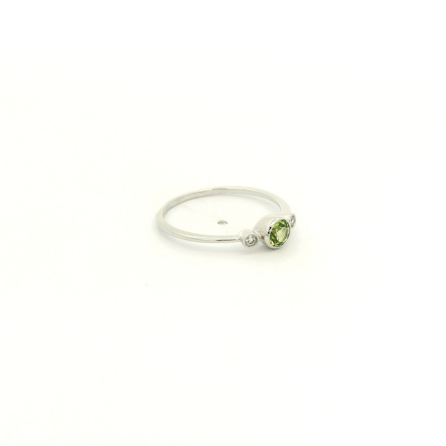 A White Gold Ring with a milgrain bezel set round cut natural Peridot in the center with 2 bezel set Natural Diamonds at Forever Rox Fine Jewelry, Lake Tahoes Best Jewelry Store

