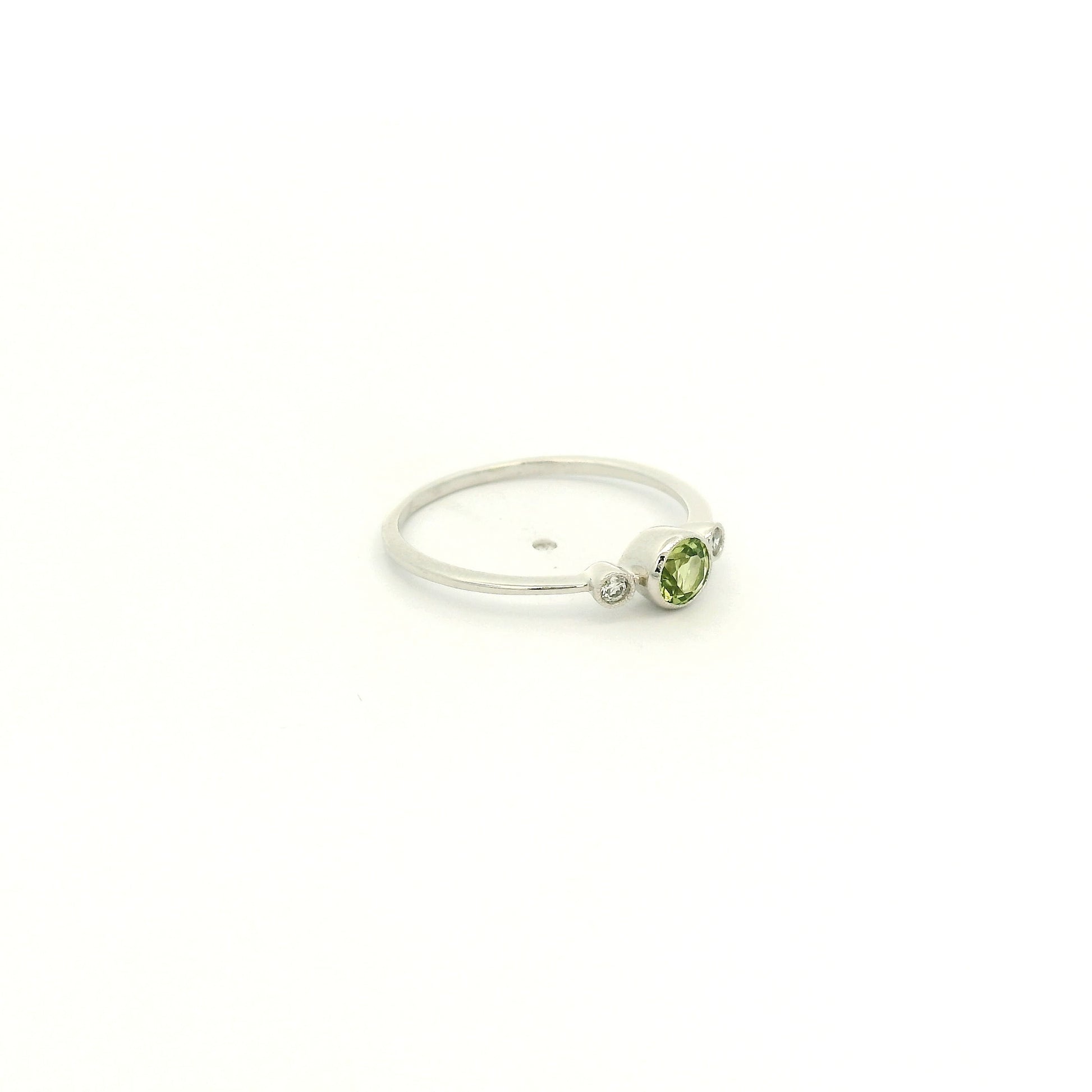A White Gold Ring with a milgrain bezel set round cut natural Peridot in the center with 2 bezel set Natural Diamonds at Forever Rox Fine Jewelry, Lake Tahoes Best Jewelry Store
