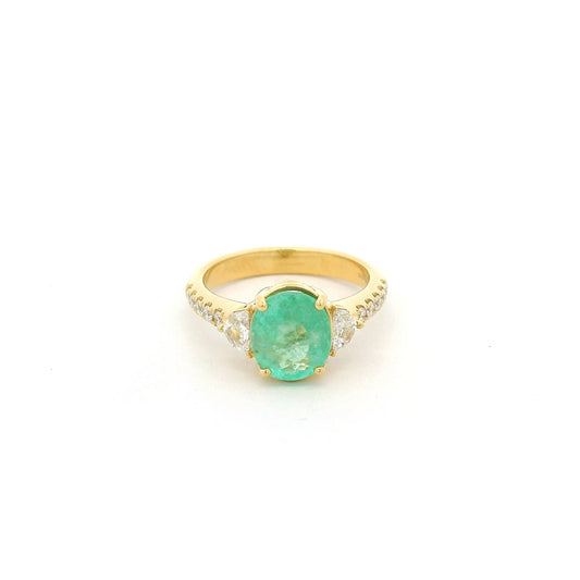 A Yellow Gold Ring with a prong set oval cut natural Green Paraíba Tourmaline in the center with two chevron cut diamonds next to it and diamonds down the shank at Forever Rox Fine Jewelry, Lake Tahoes Best Jewelry Store.