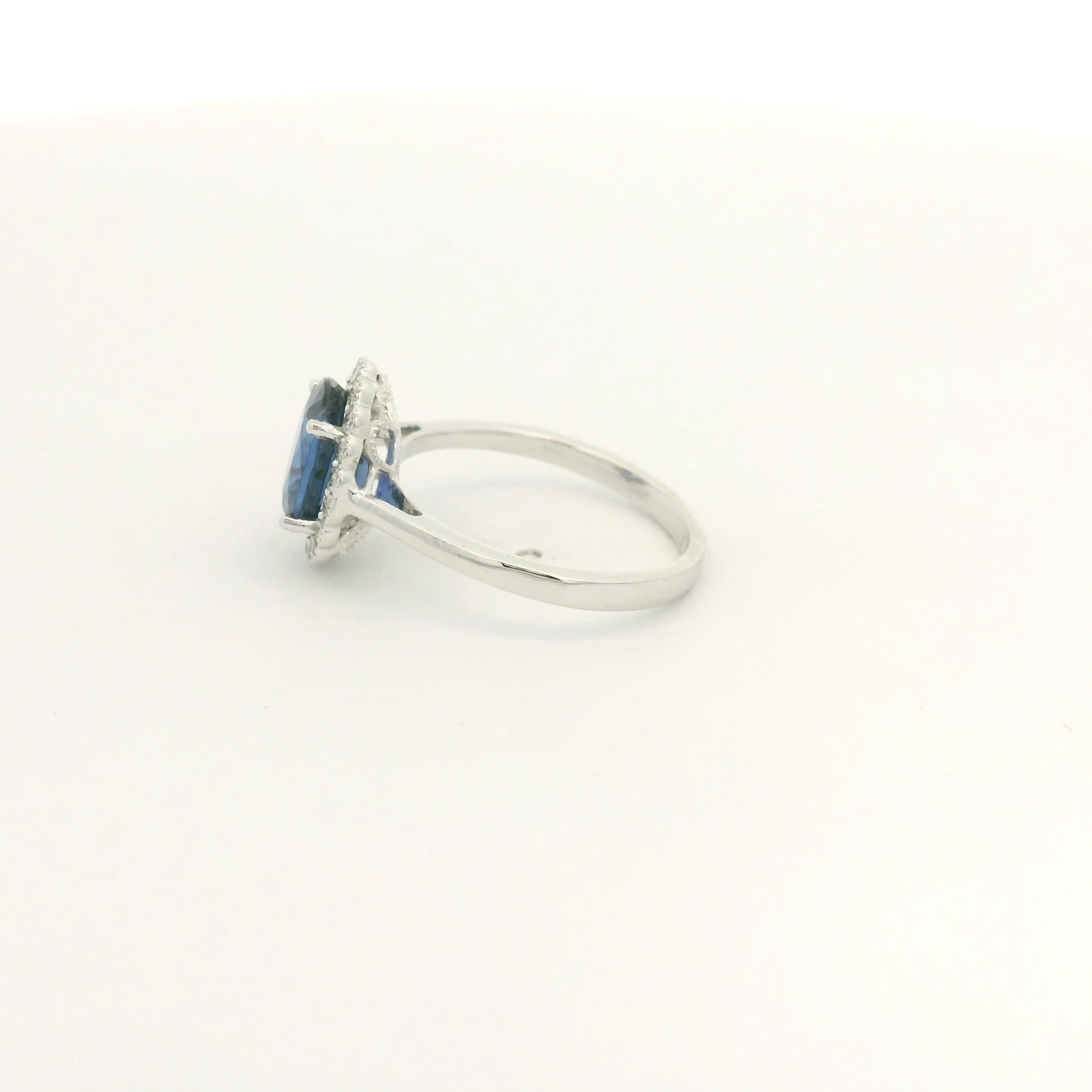 A White Gold Ring with a prong set oval cut natural Ceylon Sapphire in the center with a diamond halo with milgrain at Forever Rox Fine Jewelry, Lake Tahoes Best Jewelry Store