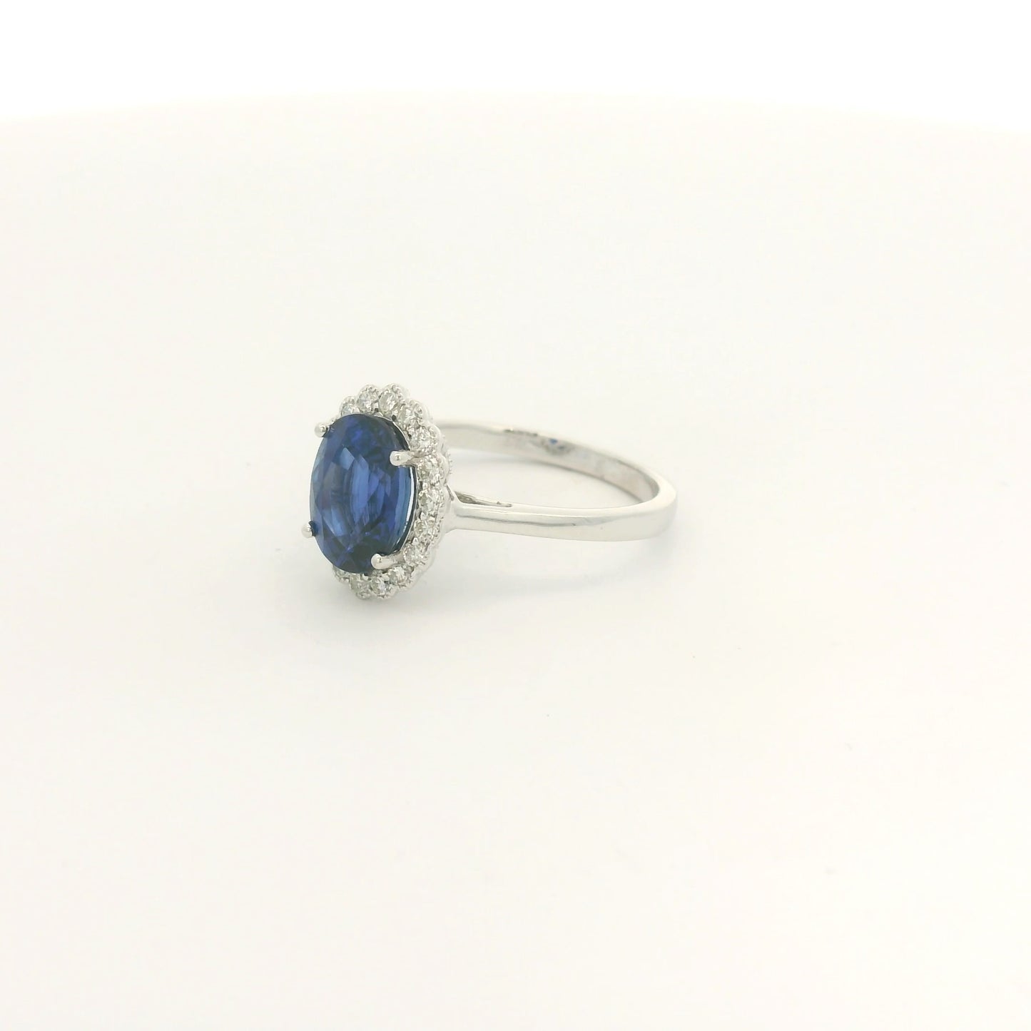 A White Gold Ring with a prong set oval cut natural Ceylon Sapphire in the center with a diamond halo with milgrain at Forever Rox Fine Jewelry, Lake Tahoes Best Jewelry Store