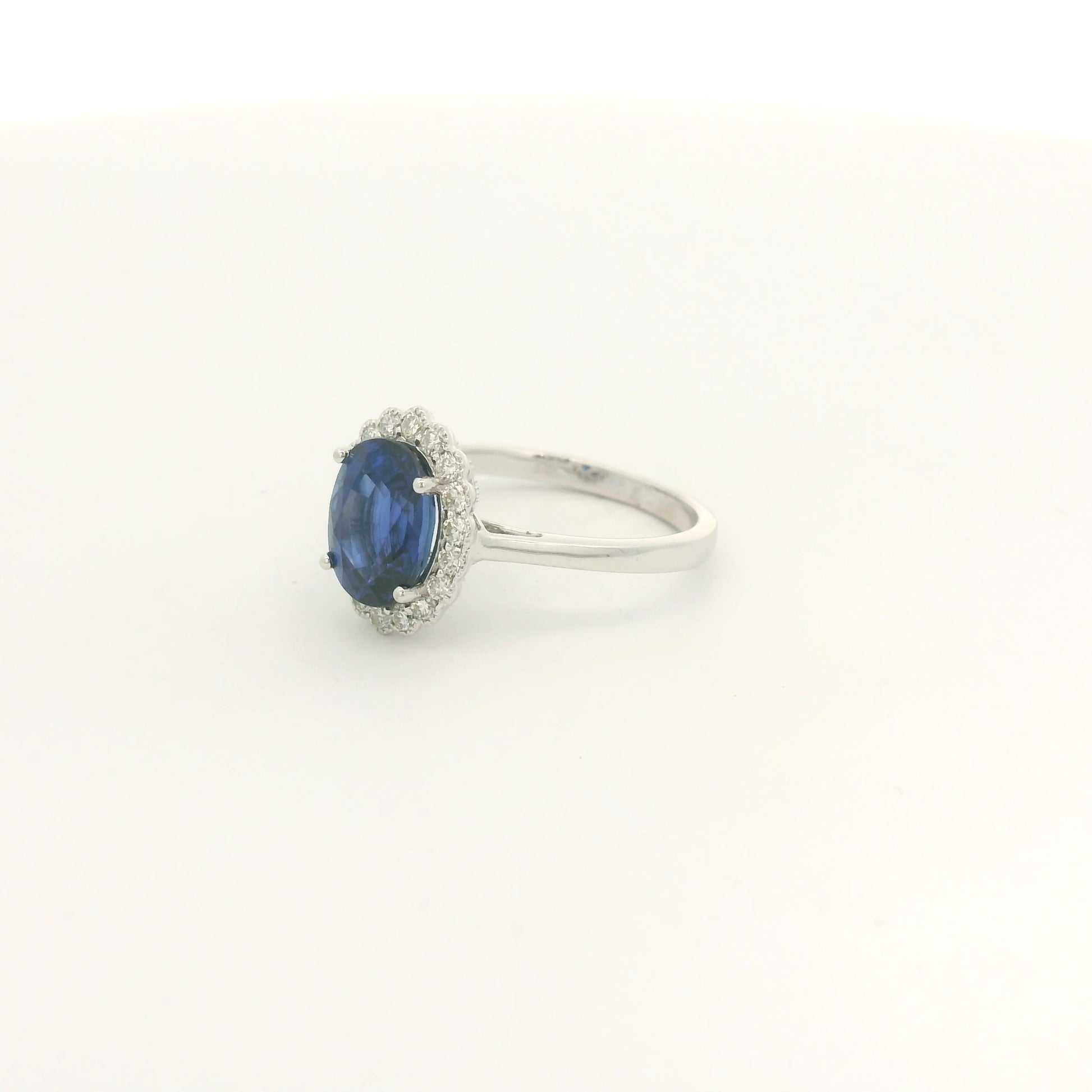 A White Gold Ring with a prong set oval cut natural Ceylon Sapphire in the center with a diamond halo with milgrain at Forever Rox Fine Jewelry, Lake Tahoes Best Jewelry Store