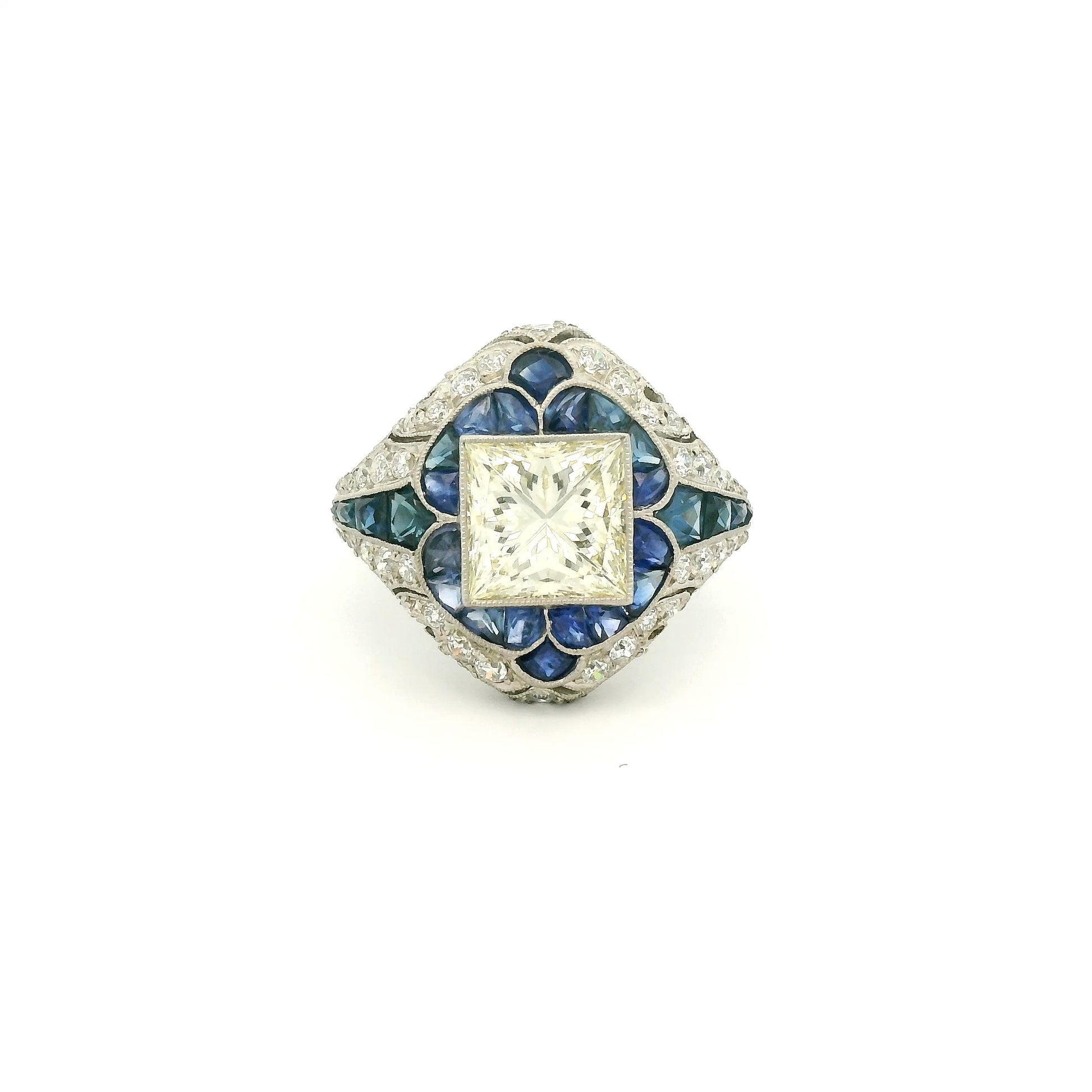 A Platinum Ring with a bezel set princess cut natural Diamond in the center with Sapphire and diamonds all around the ring at Forever Rox Fine Jewelry, Lake Tahoes Best Jewelry Store