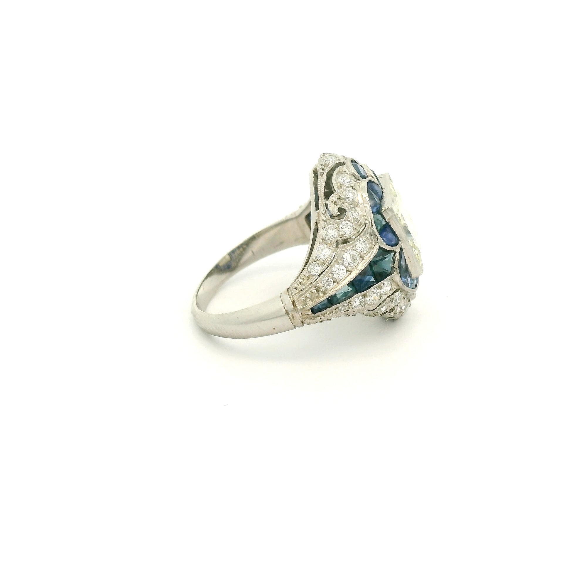 A Platinum Ring with a bezel set princess cut natural Diamond in the center with Sapphire and diamonds all around the ring at Forever Rox Fine Jewelry, Lake Tahoes Best Jewelry Store