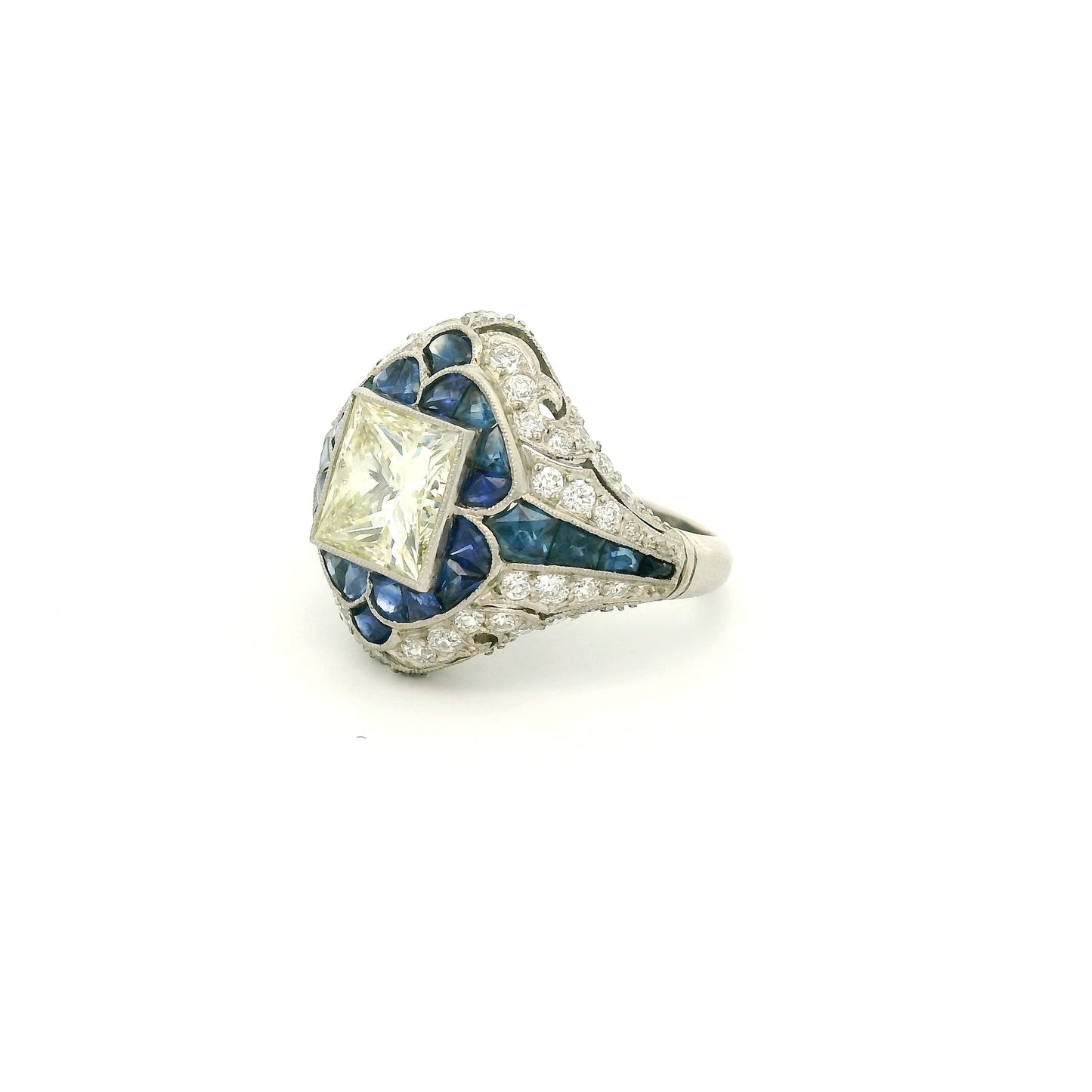 A Platinum Ring with a bezel set princess cut natural Diamond in the center with Sapphire and diamonds all around the ring at Forever Rox Fine Jewelry, Lake Tahoes Best Jewelry Store