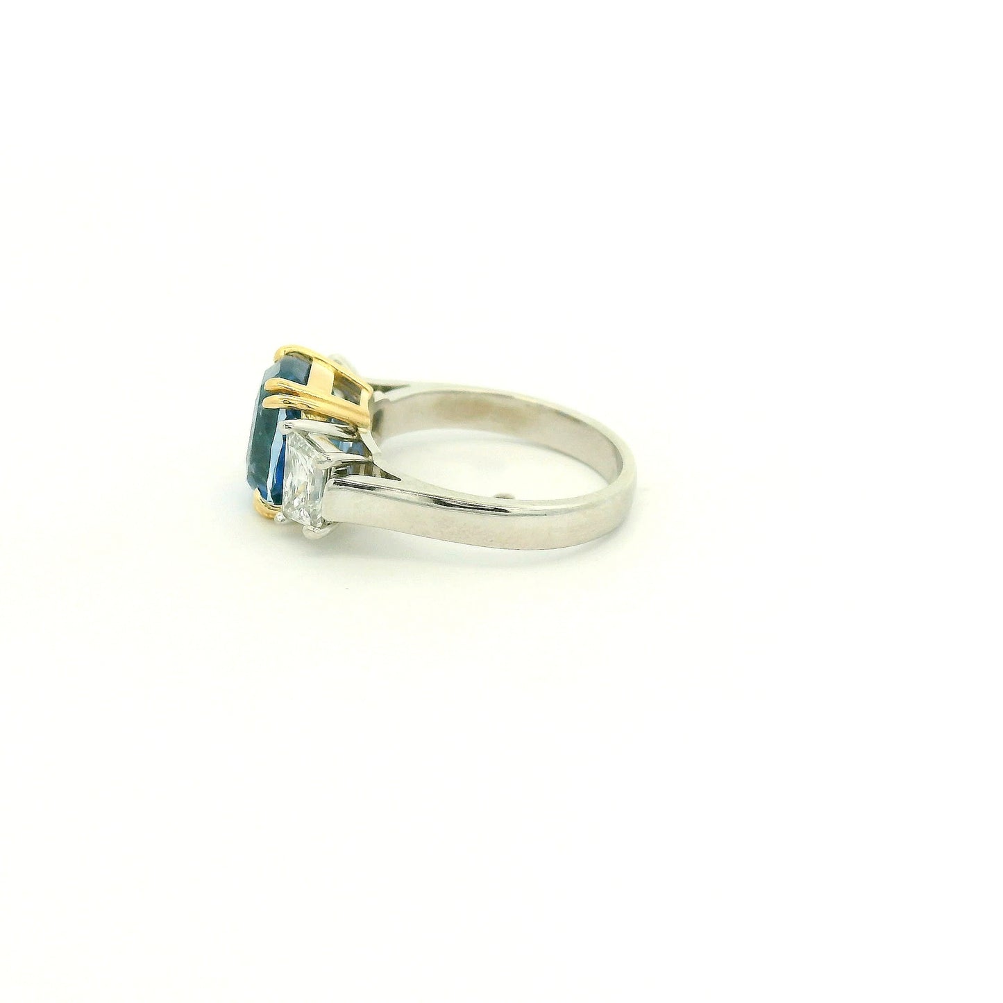 A Platinum & Yellow Gold Ring with a prong set natural TGC Certified No Heat Cushion Cut Cornflower Blue Sapphire & 2 Trapazoid Cut Diamonds at Forever Rox Fine Jewelry, Lake Tahoes Best Jewelry Store