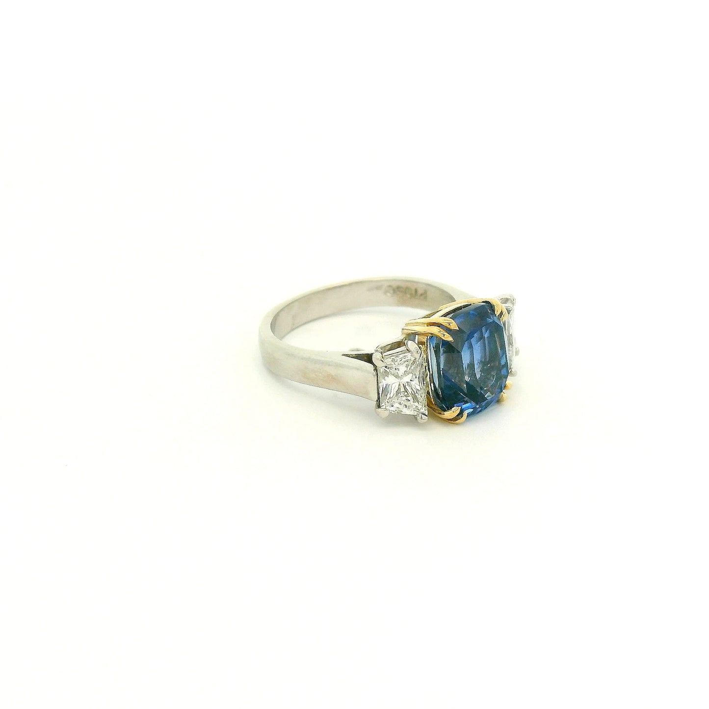 A Platinum & Yellow Gold Ring with a prong set natural TGC Certified No Heat Cushion Cut Cornflower Blue Sapphire & 2 Trapazoid Cut Diamonds at Forever Rox Fine Jewelry, Lake Tahoes Best Jewelry Store