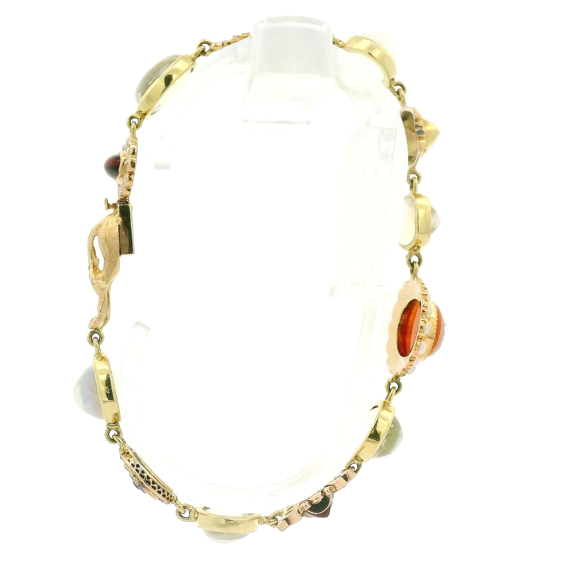 A vintage gold bracelet featuring a central orange carved shell cameo surrounded by small moonstones, with other gold links and stones at Forever Rox Fine Jewelry, Lake Tahoes Best Jewelry Store