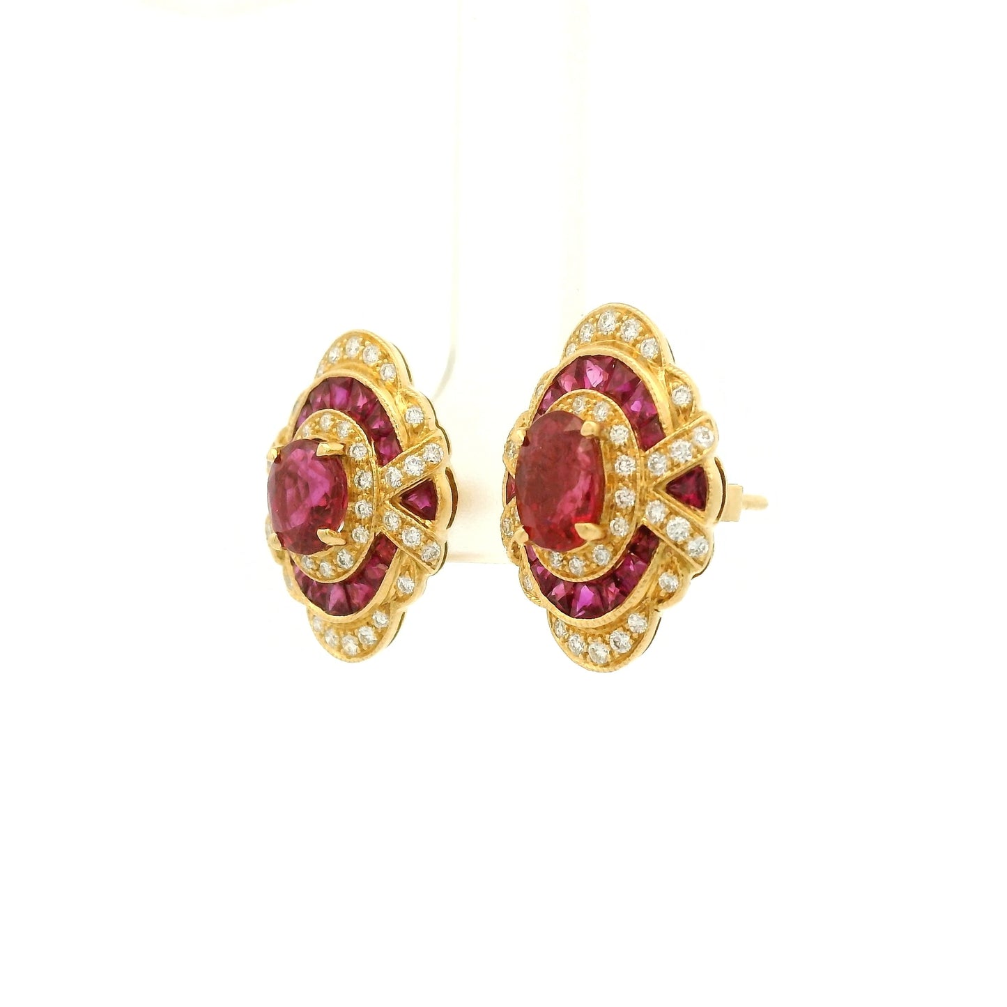 A Pair of Yellow Gold Earrings with prong set oval cut natural Rubies in the center with french cut rubies and diamonds around them at Forever Rox Fine Jewelry, Lake Tahoes Best Jewelry Store