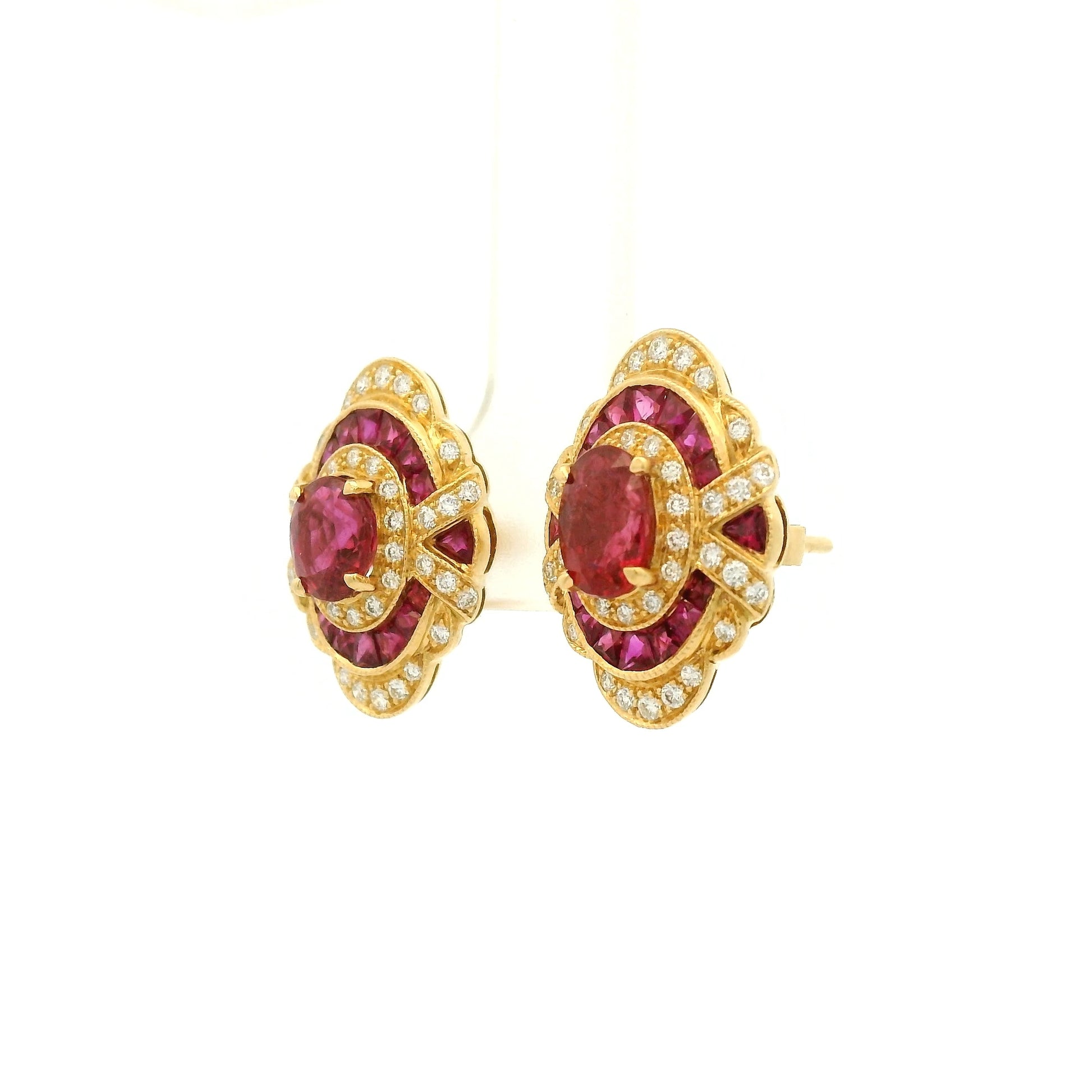 A Pair of Yellow Gold Earrings with prong set oval cut natural Rubies in the center with french cut rubies and diamonds around them at Forever Rox Fine Jewelry, Lake Tahoes Best Jewelry Store
