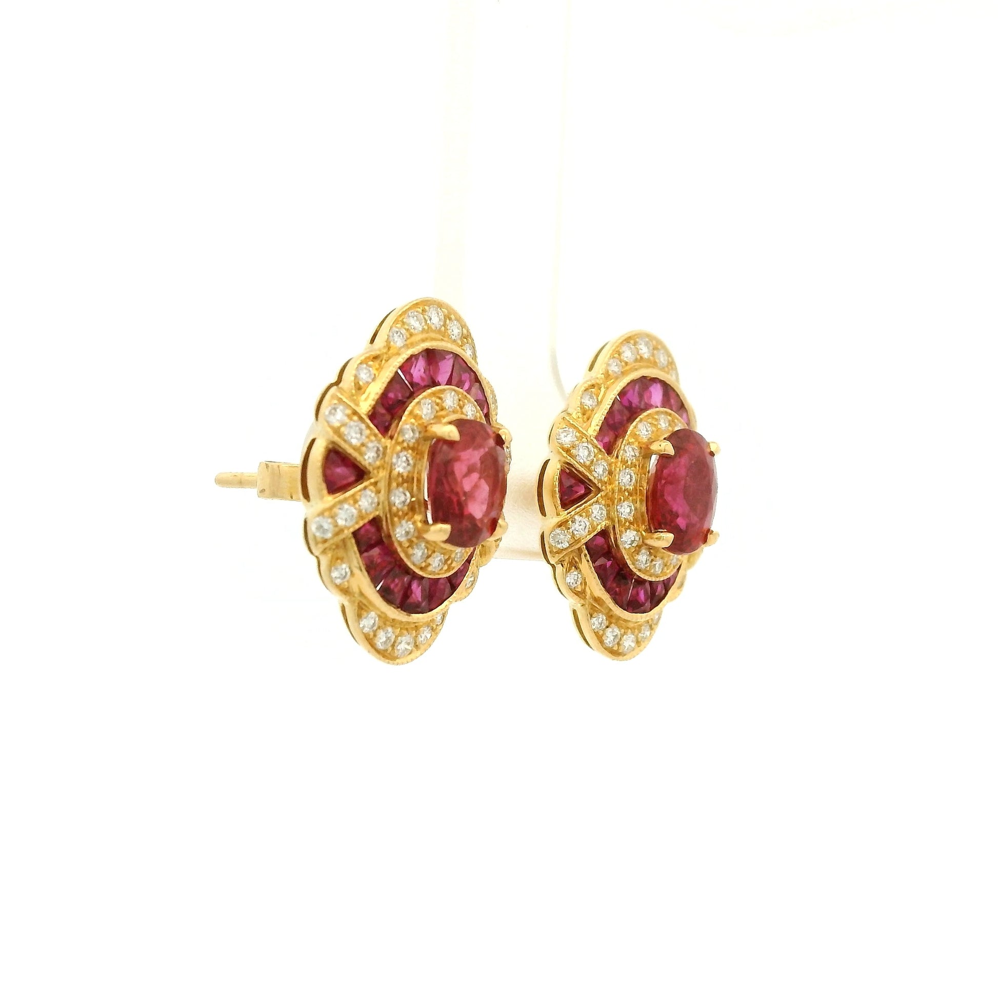 A Pair of Yellow Gold Earrings with prong set oval cut natural Rubies in the center with french cut rubies and diamonds around them at Forever Rox Fine Jewelry, Lake Tahoes Best Jewelry Store