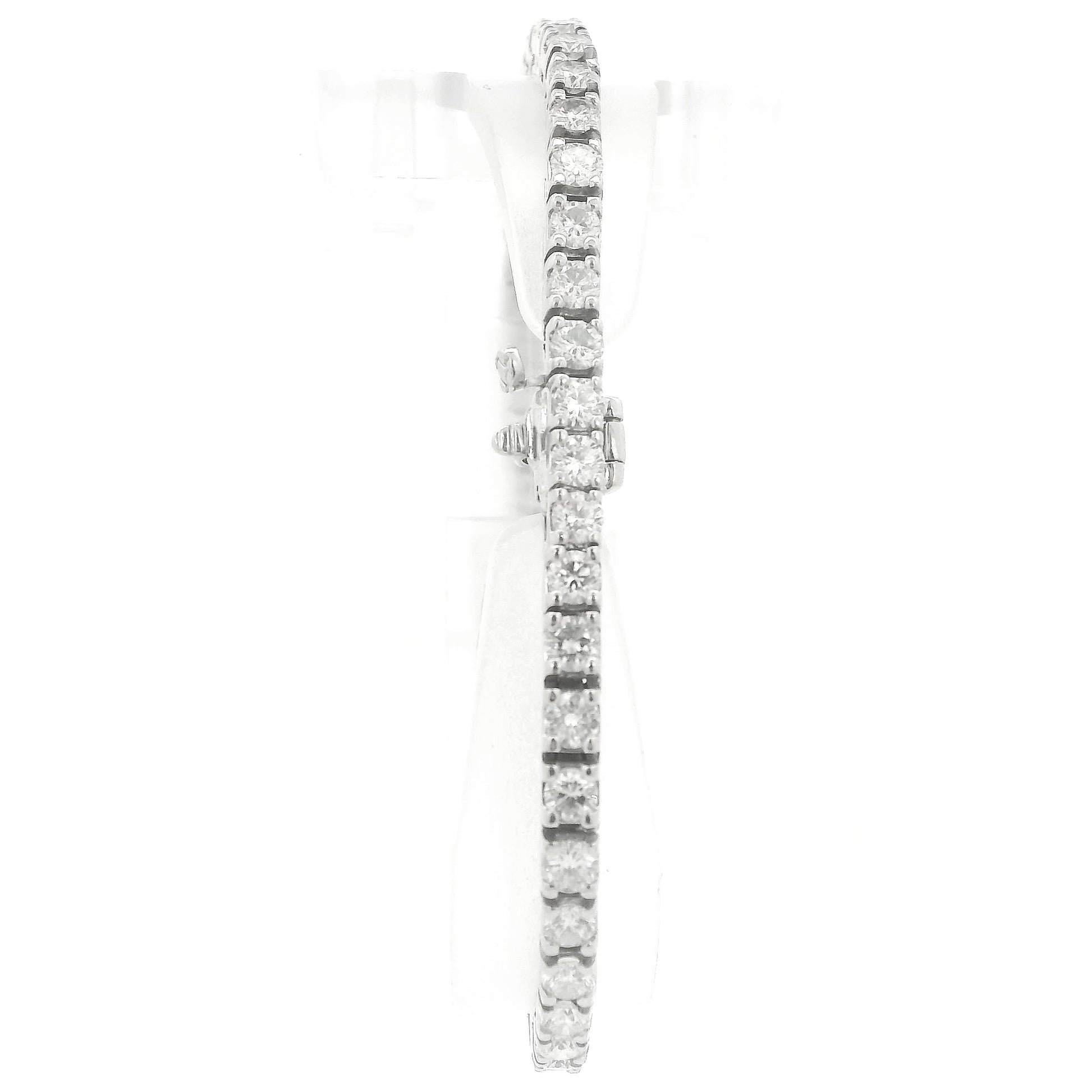A single white gold diamond tennis bracelet displayed vertically on a clear stand against a plain white background at Forever Rox Fine Jewelry, Lake Tahoes Best Jewelry Store