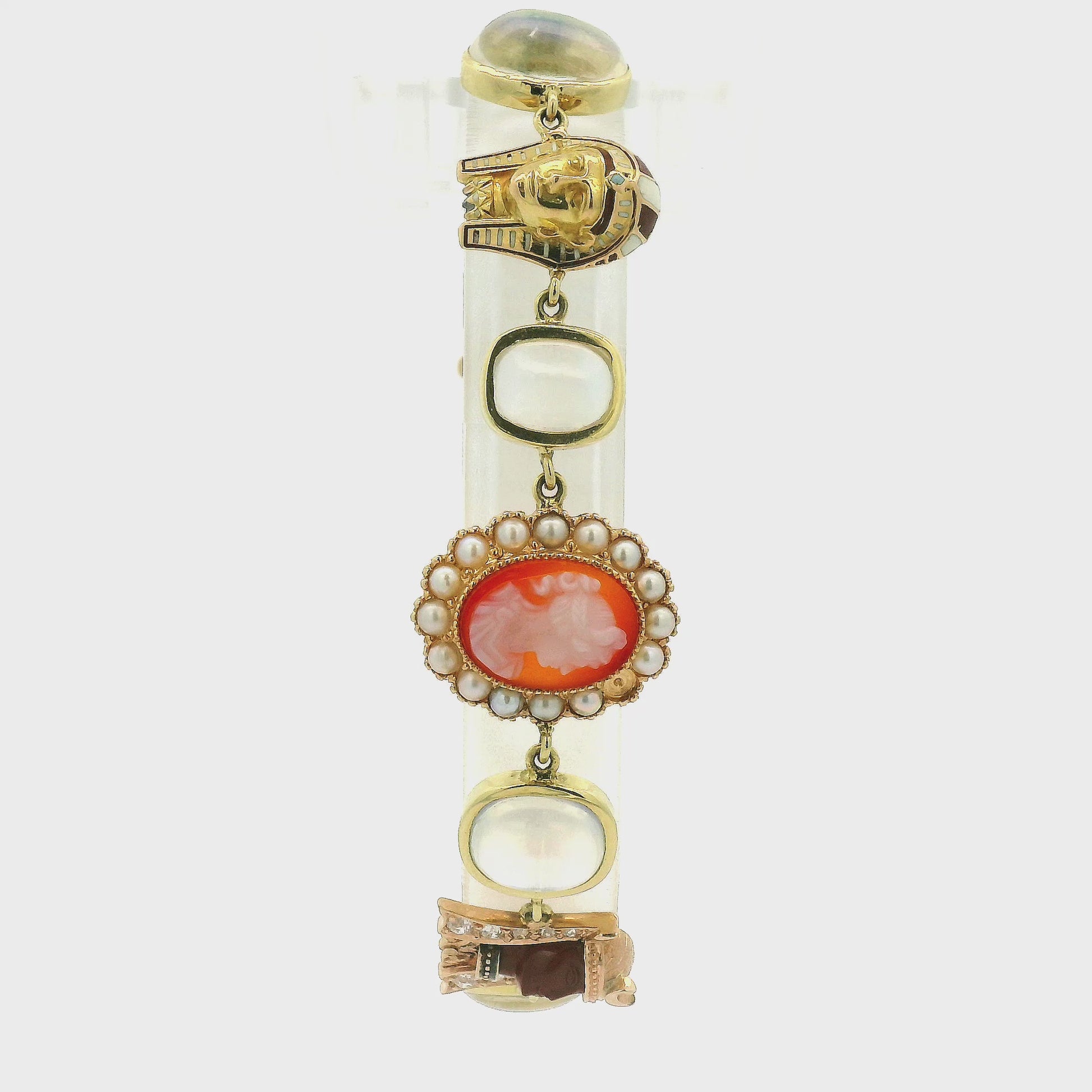 A vintage gold bracelet featuring a central orange carved shell cameo surrounded by small moonstones, with other gold links and stones at Forever Rox Fine Jewelry, Lake Tahoes Best Jewelry Store