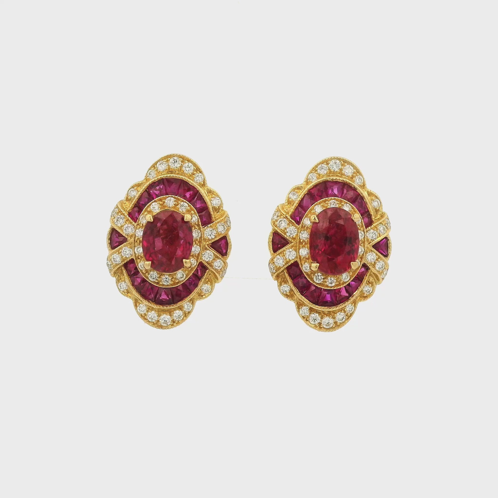 A Pair of Yellow Gold Earrings with prong set oval cut natural Rubies in the center with french cut rubies and diamonds around them at Forever Rox Fine Jewelry, Lake Tahoes Best Jewelry Store